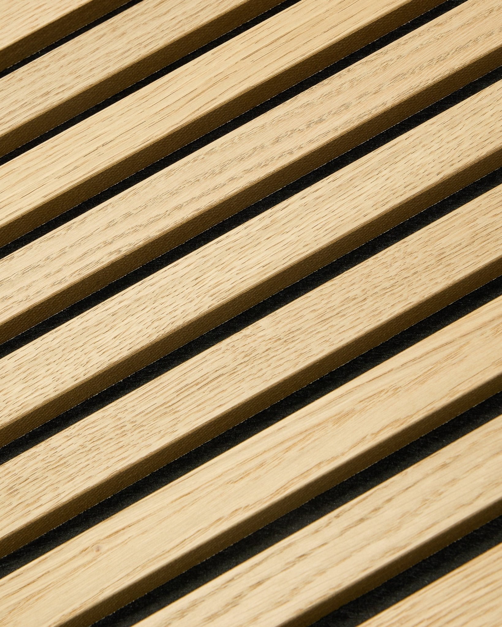 Närbild av WoodUpp Akupixel Classic Oak Akustikpanel, 60x60 cm, med black filt mellan eksribborna i en randig nordisk design.