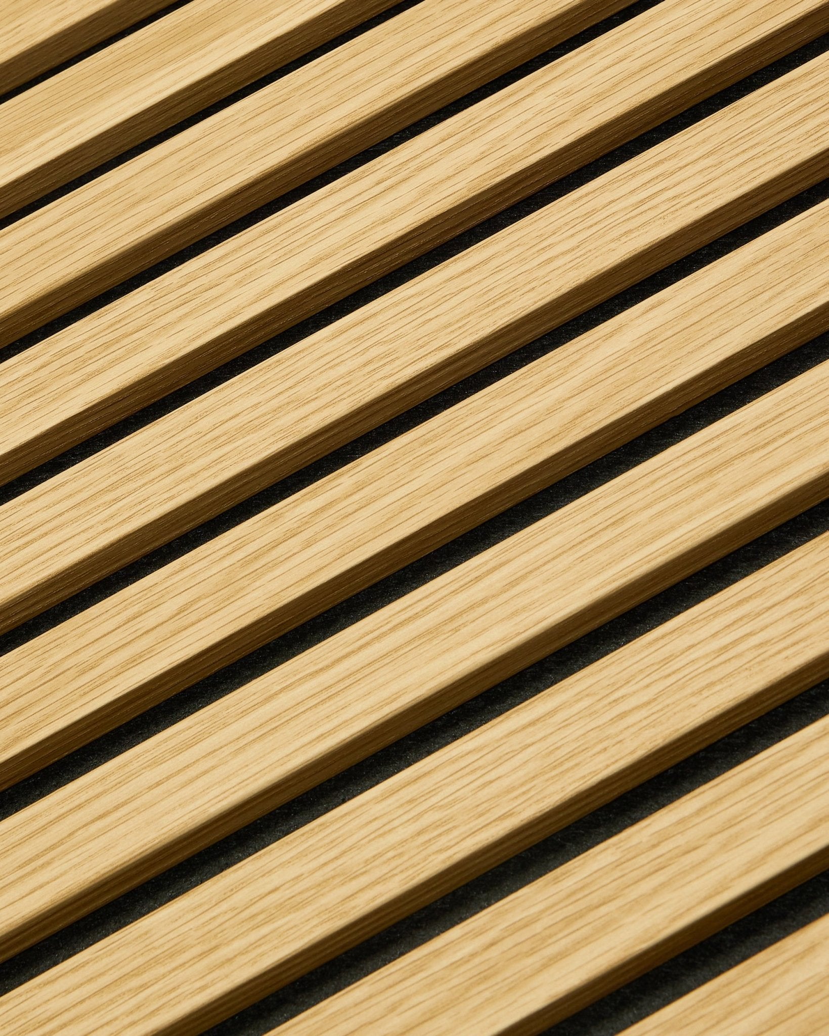 Närbild av WoodUpp Akupanel Akustikpanel i Southern Oak, 240 x 60 cm, med diagonala ribbor och mörka akustiska mellanrum för förbättrad ljudabsorption.