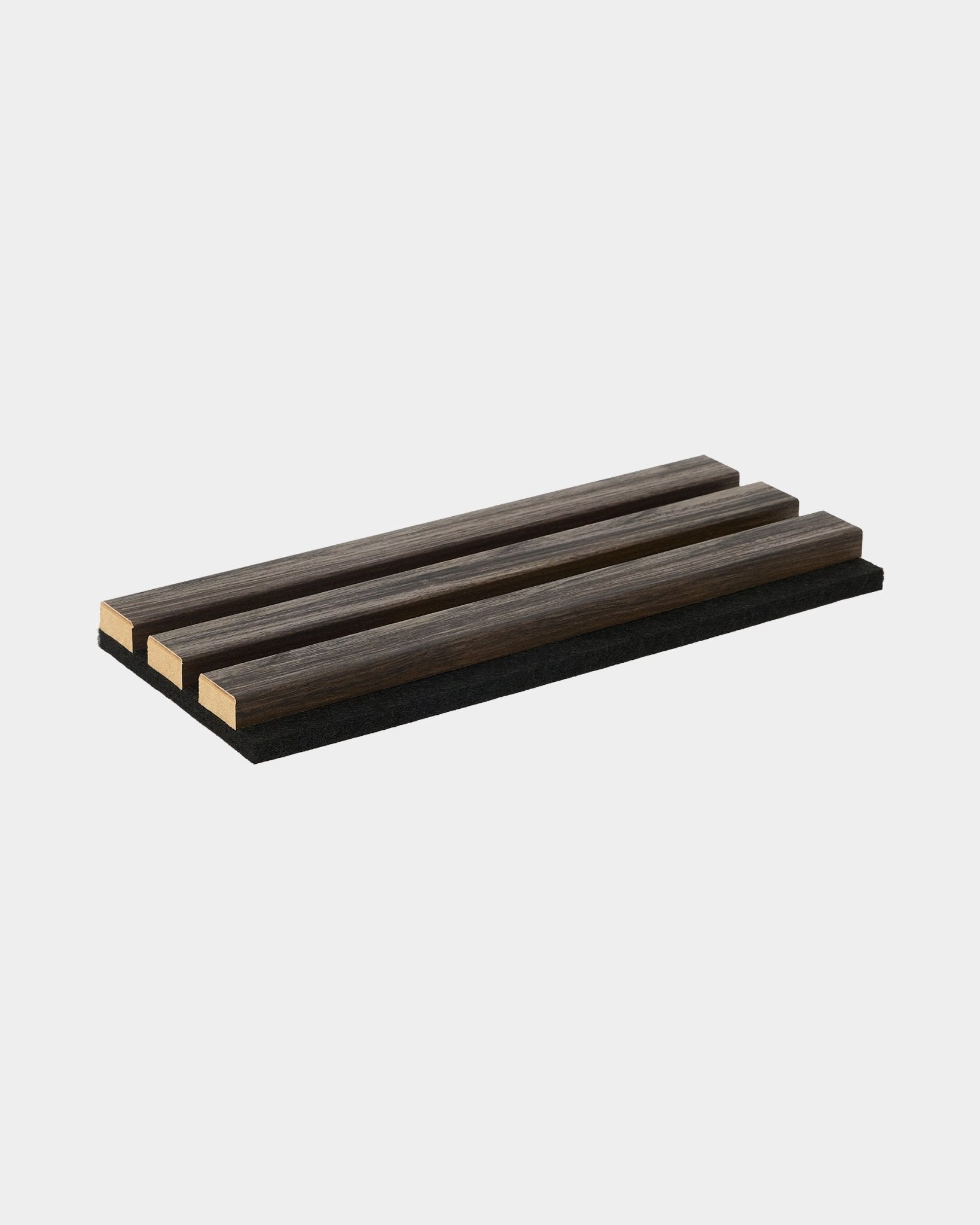 WoodUpp Essential-prov i Black Oak, ett rektangulärt grytunderlägg med tre ribbor i trä, utformat för att komplettera Nordics kollektioner av akustikpaneler i trä.