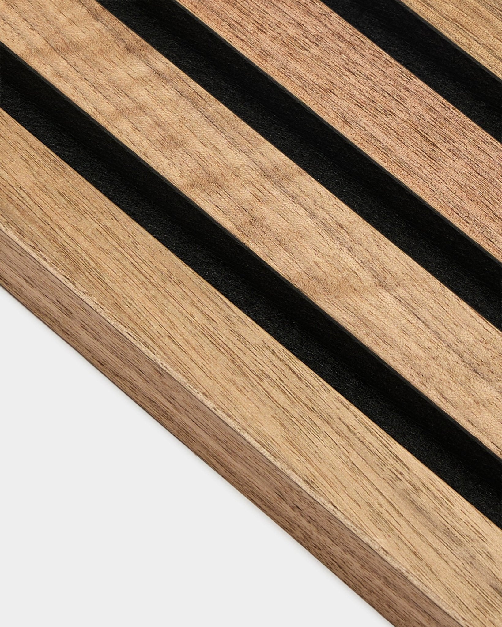 Närbild av WoodUpp Akupanel End Lamella i valnöt, 2,2 cm Akustikpanel, med parallella black ränder och synlig valnötsträets ådring mot vit bakgrund.