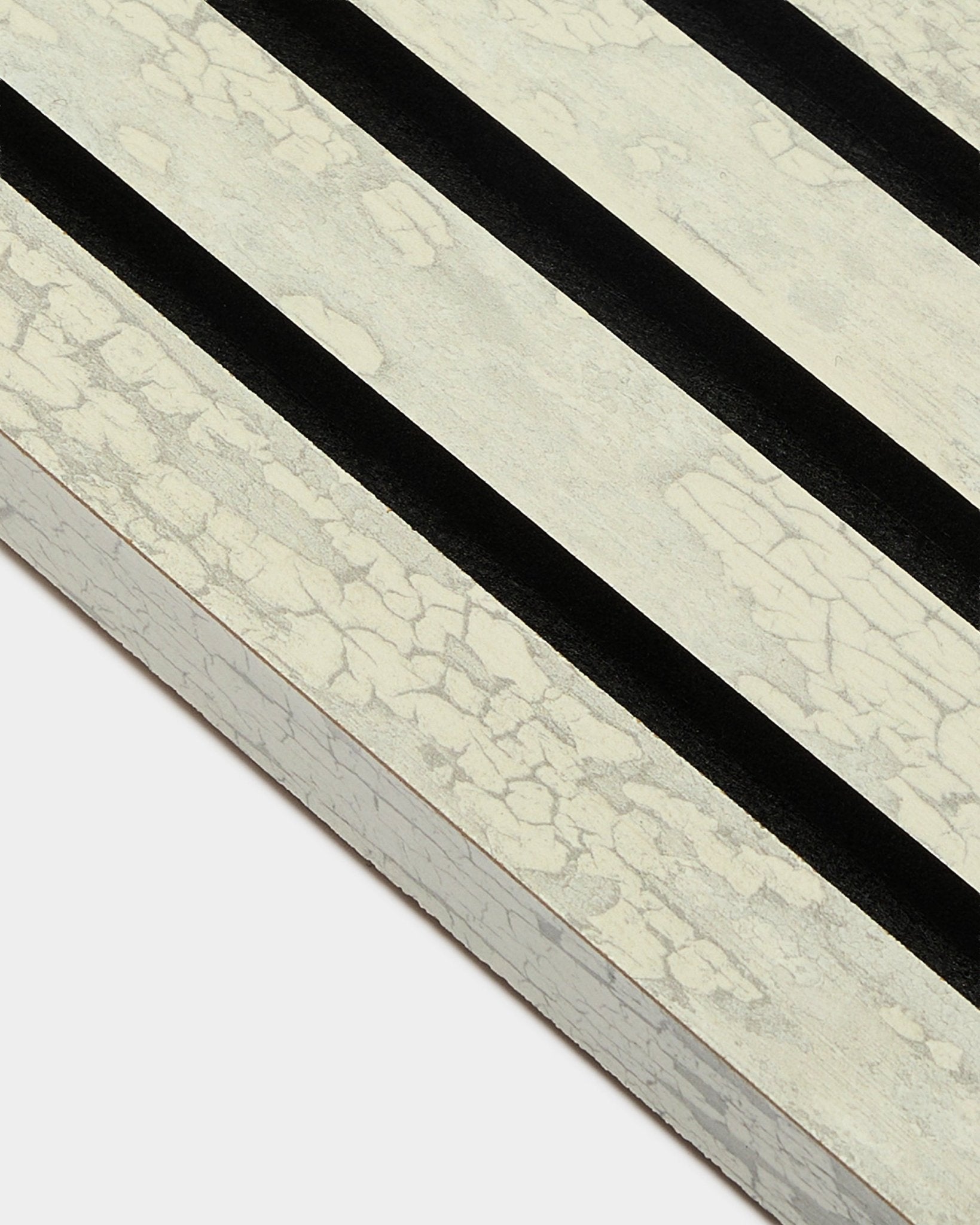 Närbild på WoodUpp Akupanel End Lamella i Oxide White (2,2 cm) med tre diagonala black ränder på en MDF-Akustikpanel-ram.