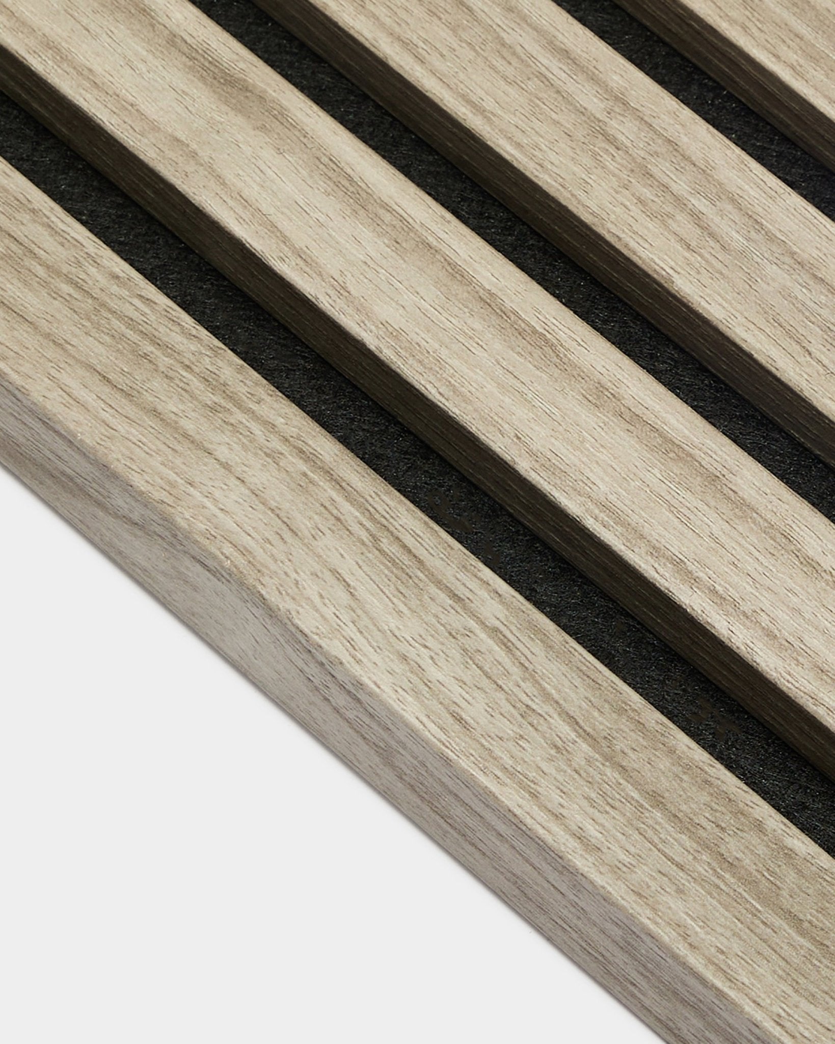 Närbild av WoodUpp Akupanel End Lamella i Weathered Oak, 2,2 cm – ljusa nordiska eklameller för akustikpaneler med black filtad baksida mot en vit bakgrund.