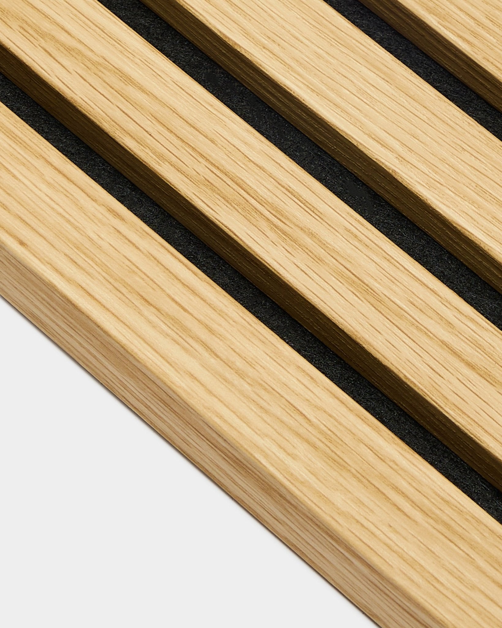 Närbild av WoodUpp Akupanel ändlamell i Southern Oak, 2,2 cm breda ribbor med black mellanrum, diagonalt arrangerade mot en ljus grey bakgrund.