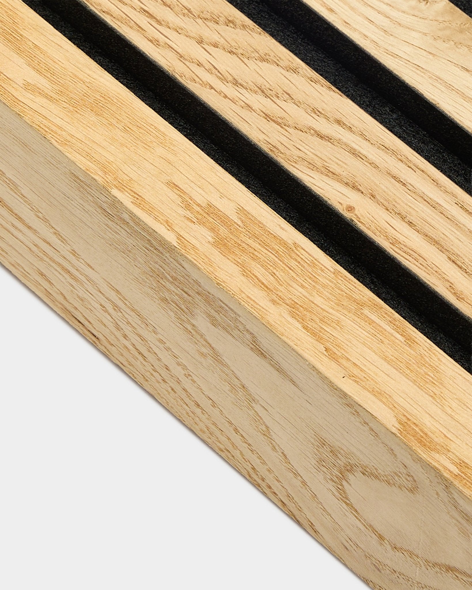 Närbild av en WoodUpp Akupanel ändlamell i Rustic Natural Oak, 6,7 cm, med parallella black spår och en MDF-ram för akustisk vägginstallation.