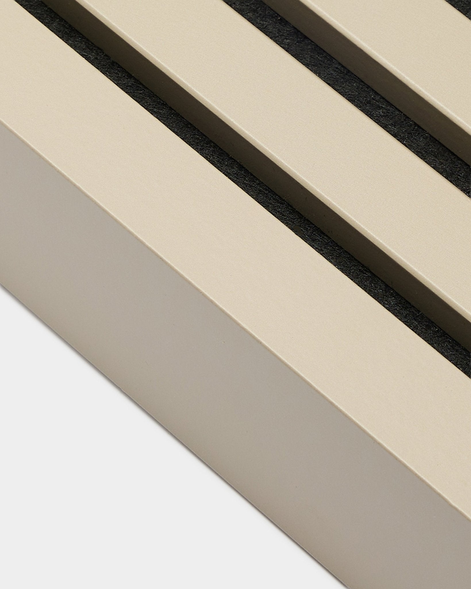 Närbild av WoodUpp End Lamella i Stone-utförande, 6,7 cm bred – installationstillbehör för MDF-ramar eller Akupanel akustikpaneler. Beige panelribbor med black mellanrum.