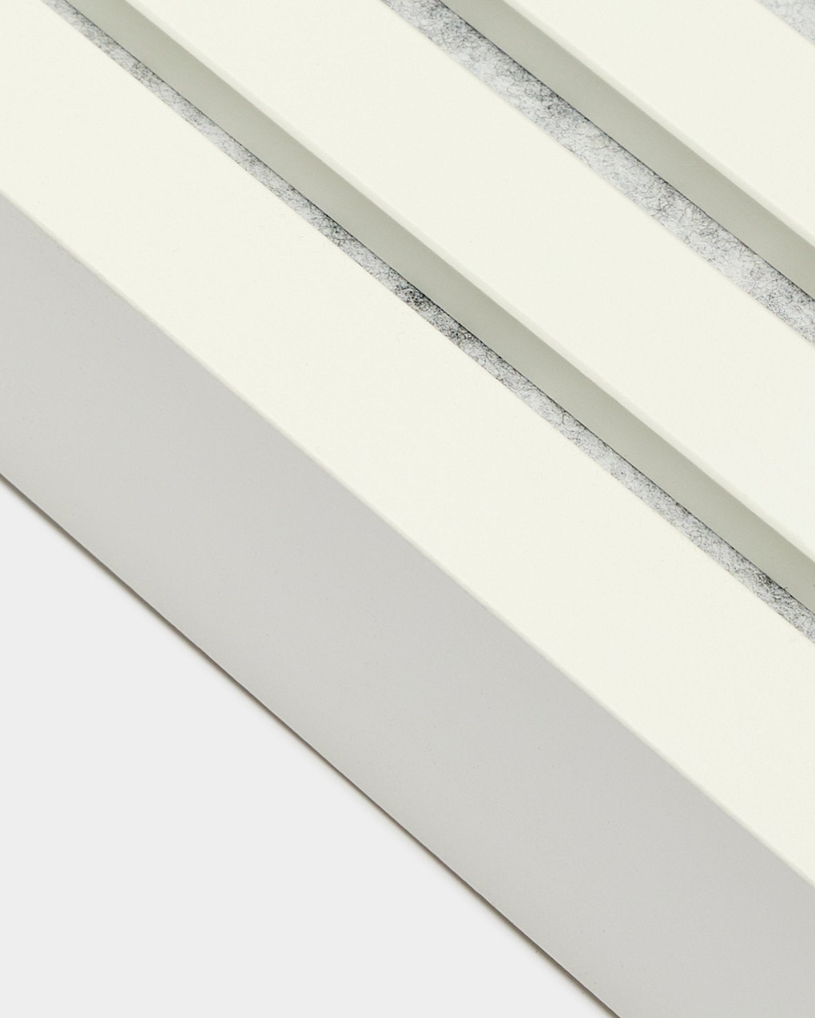Närbild på WoodUpp ändlamell i Snow, 6,7 cm bred, med MDF-ram, dubbla spår och en texturerad grey-yta för Akupanel Akustikpanel installation.