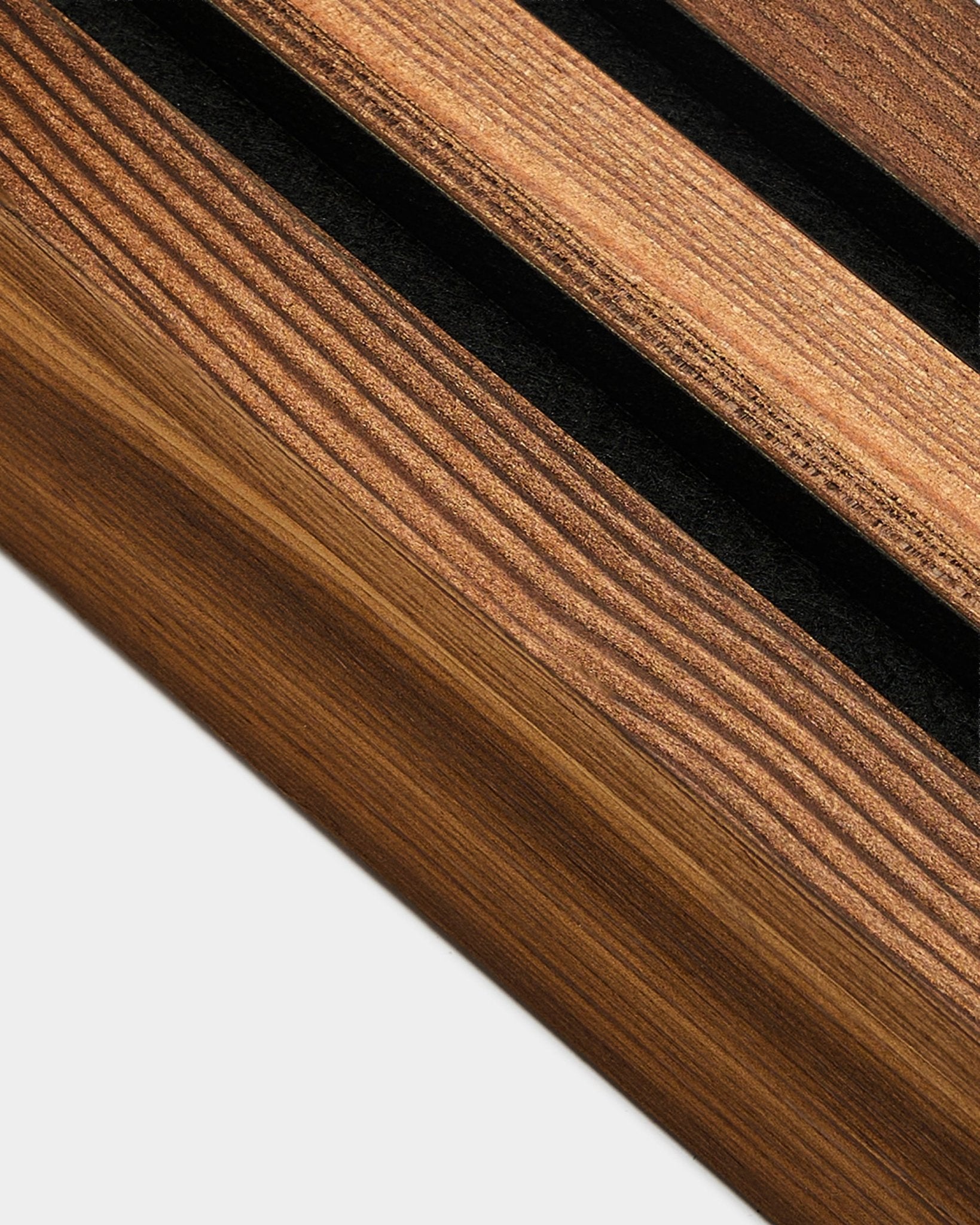 Detaljerad vy av WoodUpp ändlamell i Rustic Smoked Larch, 6,7 cm, utformad för att avsluta Akupanel Akustikpanel kanter på ljusa colored väggar.