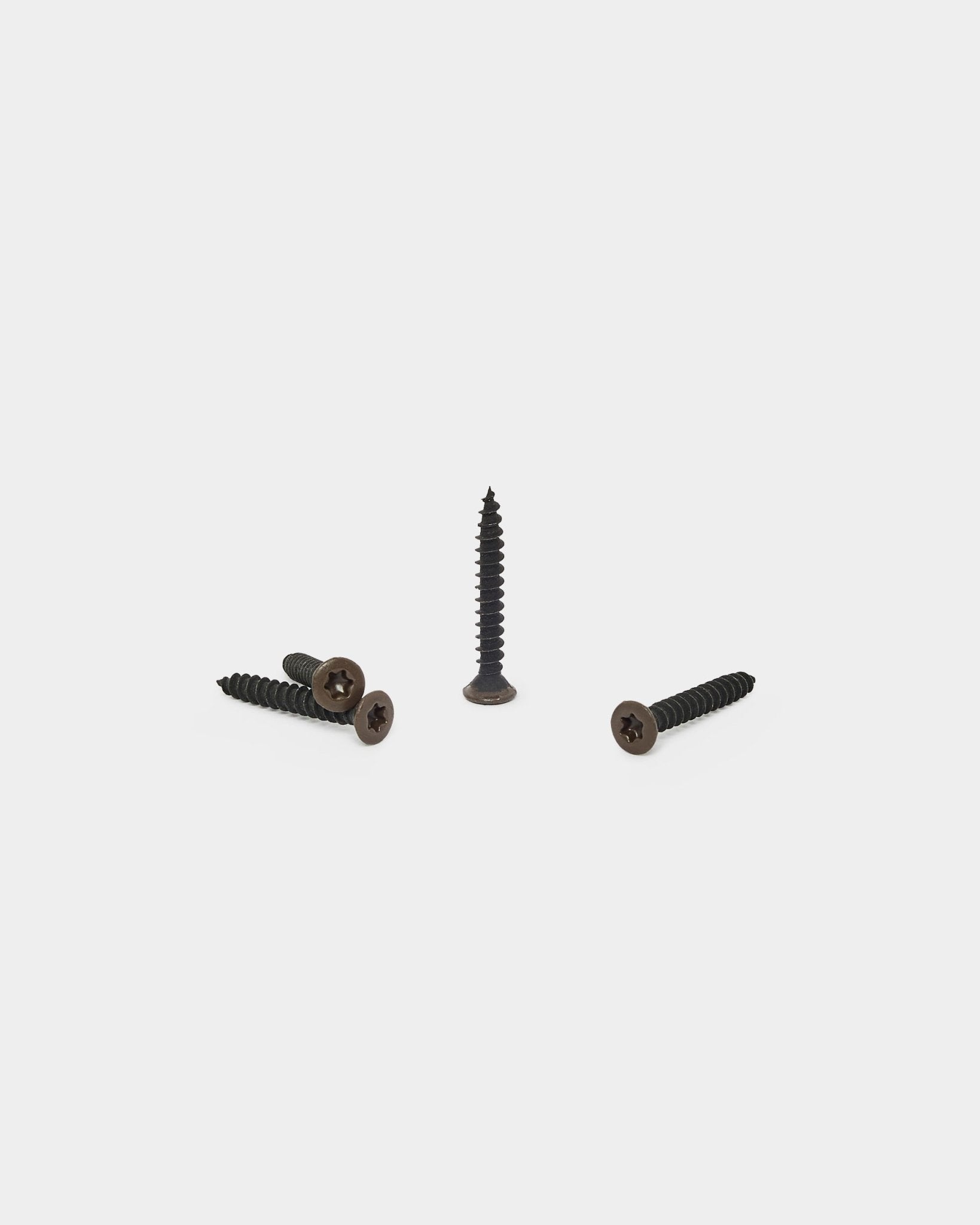 Tre bronzed brown WoodUpp-skruvar, en stående och två liggande, utformade för att fästa filtunderlaget på Akupanel akustikpaneler. Förpackning med 100 st.