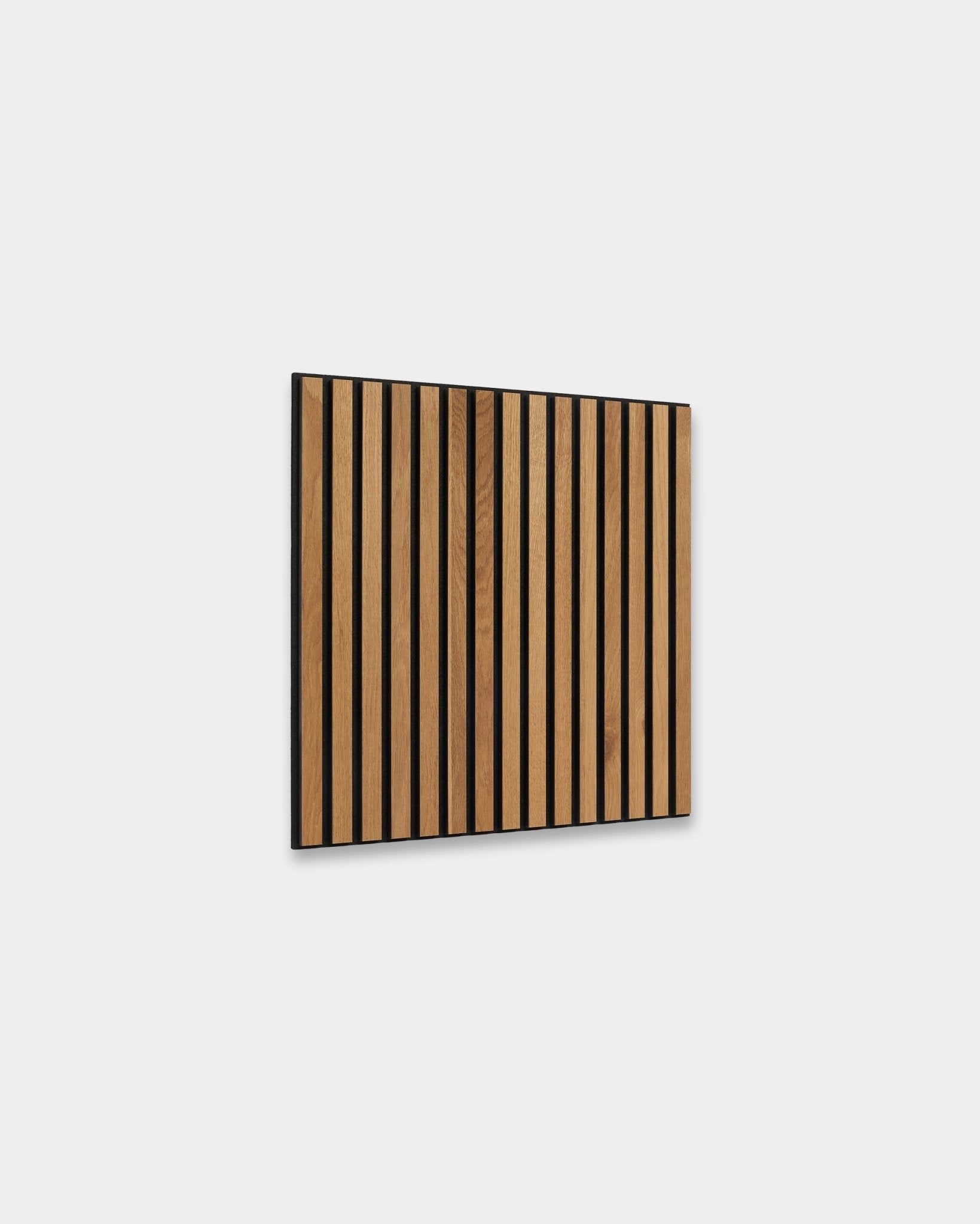 WoodUpp Akupixel Rustic Brown Oak 60x60cm Akustikpanel med vertical ribbor och black mellanrum, visad mot en ljusgrå nordisk innervägg.