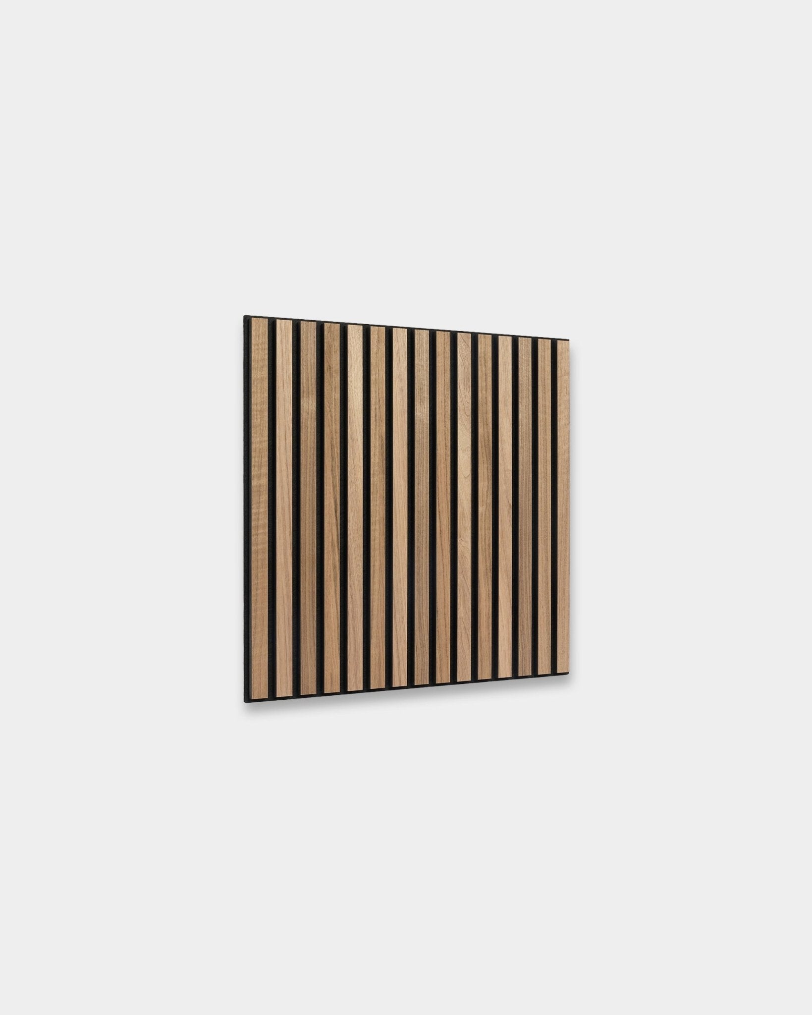 WoodUpp Akupixel Akustikpanel i valnöt, 60x60 cm, har jämnt placerade lameller i valnöt med mellanrum på black, monterade på en ljusgrå vägg i skandinavisk stil.