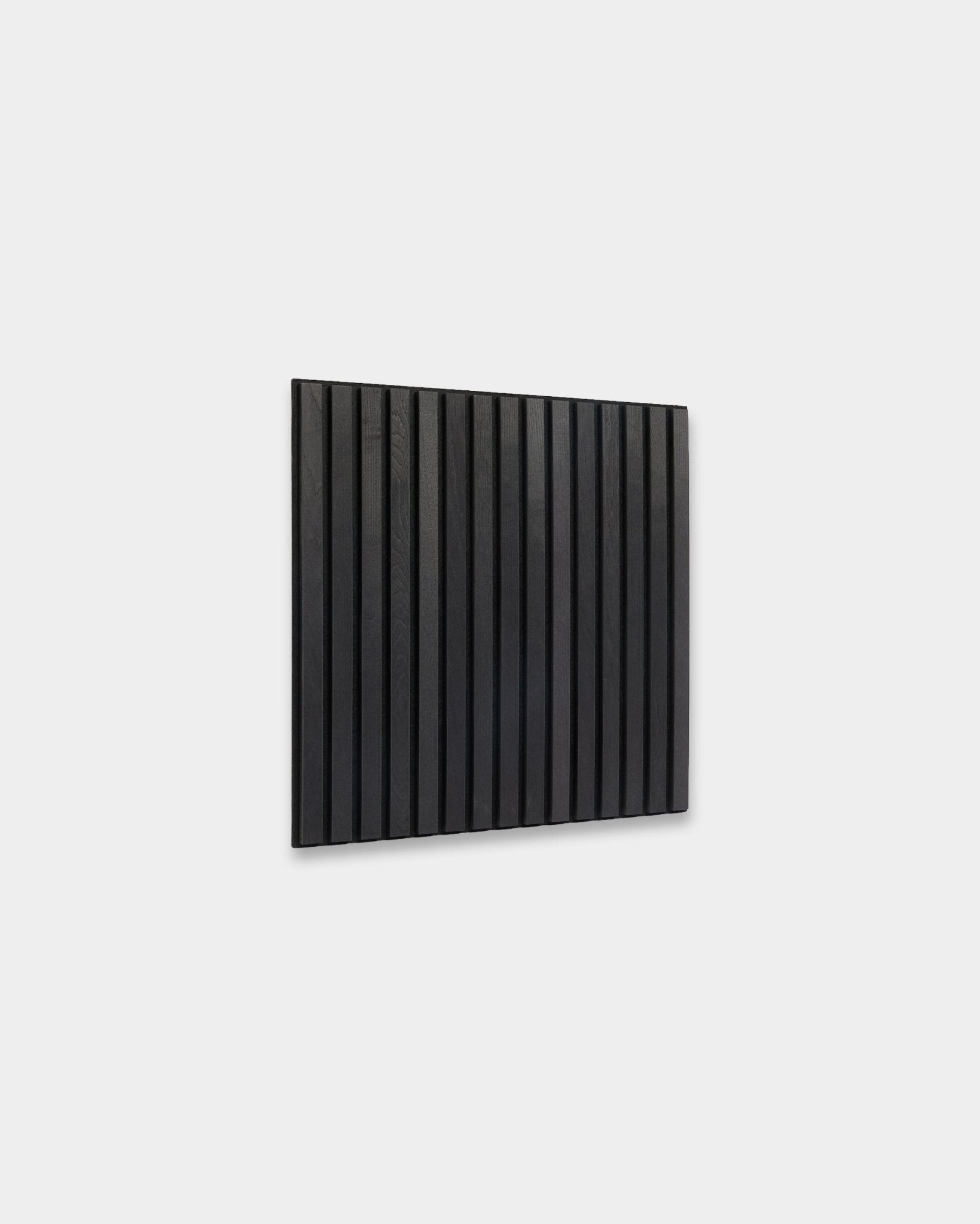 WoodUpp Akupixel Black Ash Akustikpanel (60x60 cm) med vertical träribbor monterade på en ljusgrå vägg, som visar upp minimalistisk skandinavisk design.