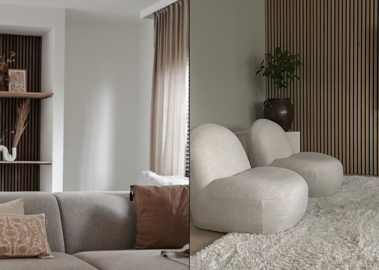 Modernt vardagsrum med neutralt tonade soffor, texturerad matta och en accentvägg med akustikpanel av träribbor, upplyst av mjukt naturligt ljus från stora fönster.
