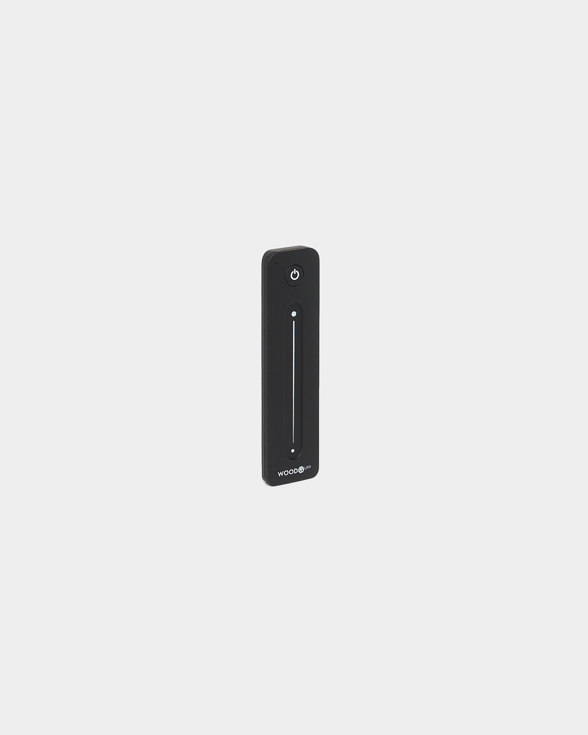 Slimmad black WoodUpp Lumi-fjärrkontroll för LED-lister, med vertical touchslider och strömknapp, kompatibel med Philips Hue, visad mot vit bakgrund.