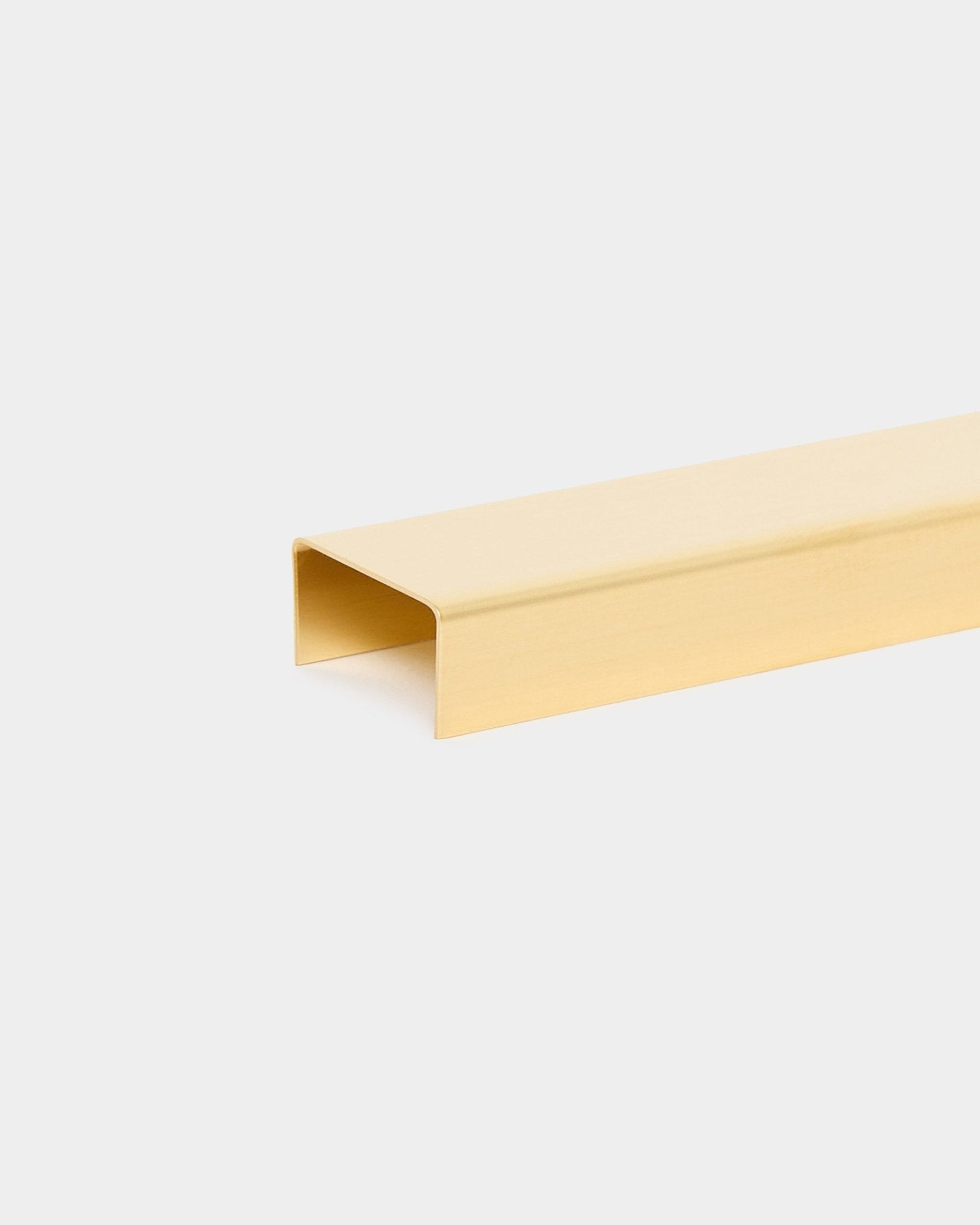 Liva | Cover / Brass, 120 cm från WoodUpp är ett guldfärgat U-format metallisttillbehör för akustiska träpaneler, visat mot en ljus bakgrund.