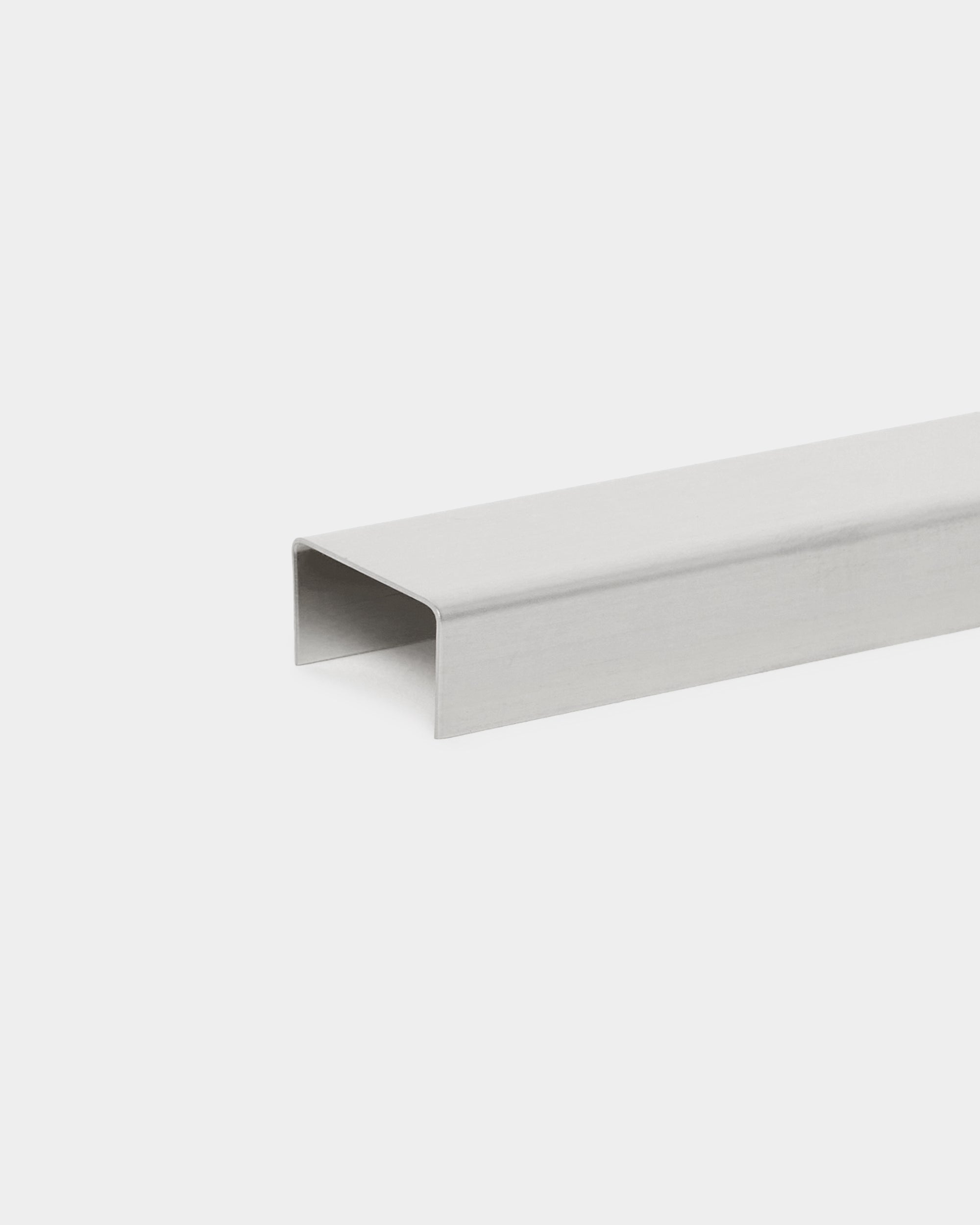 Liva Cover från WoodUpp: 60 cm polerad steel U-formad metallkanal som tillbehör, utformad för användning med Akupanel akustikpaneler, visad mot en vit bakgrund.