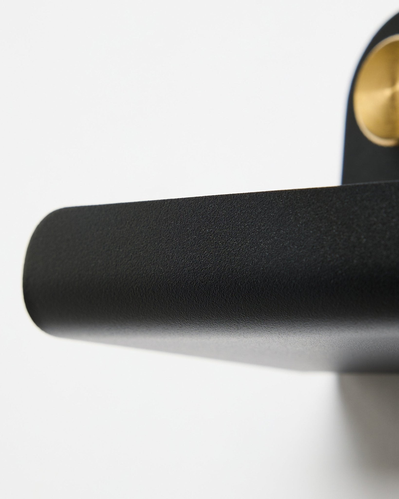 Närbild av ett dörrhandtag i black och WoodUpp Norr | Narrow Shelf i black, 51,9 cm, placerad mot en vit bakgrund.