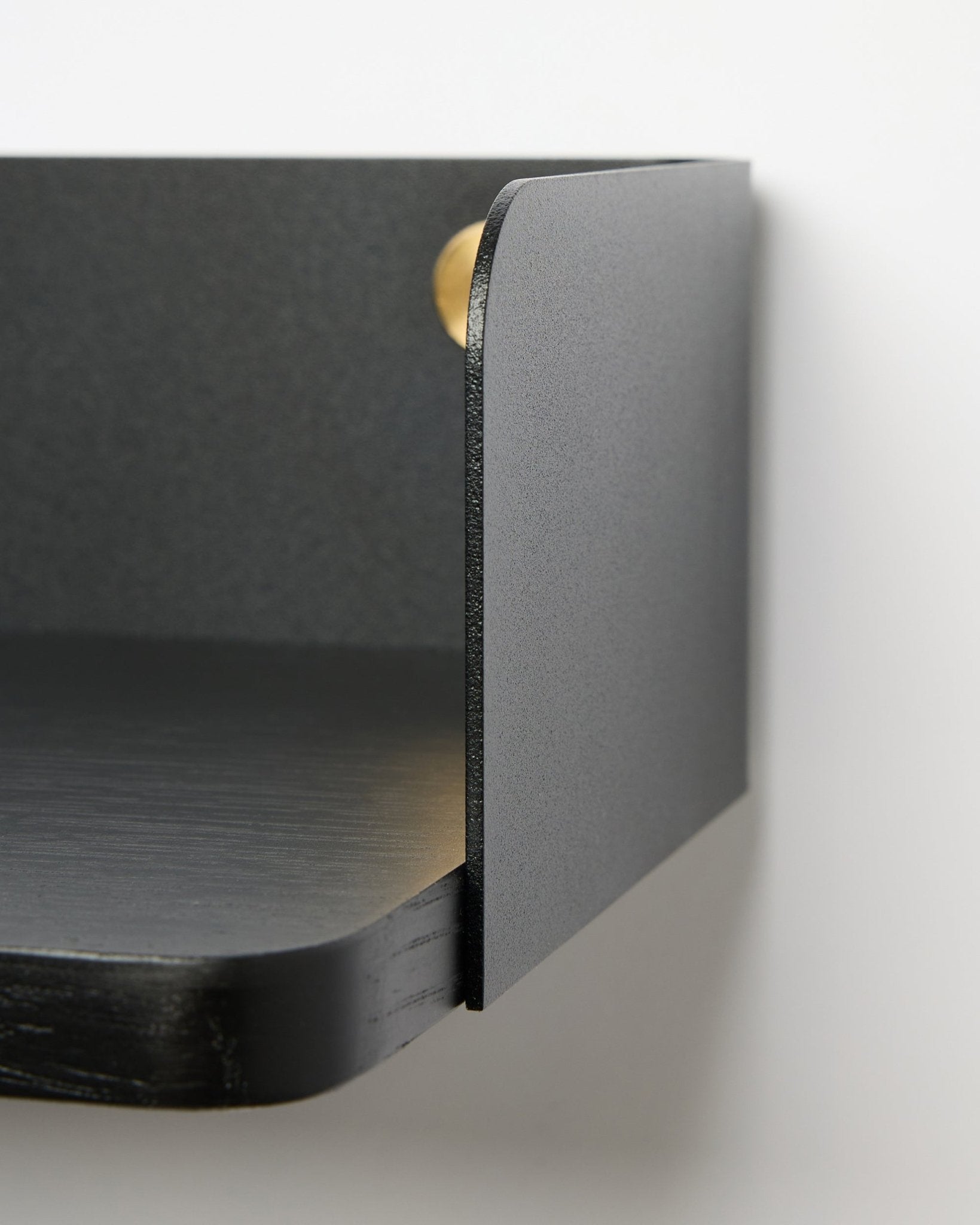 Närbild av WoodUpp Linn Bookshelf i Black Oak, 39,9 cm bred med rundade kanter och matt finish, monterad på en vit vägg. Nordisk minimalistisk stil.