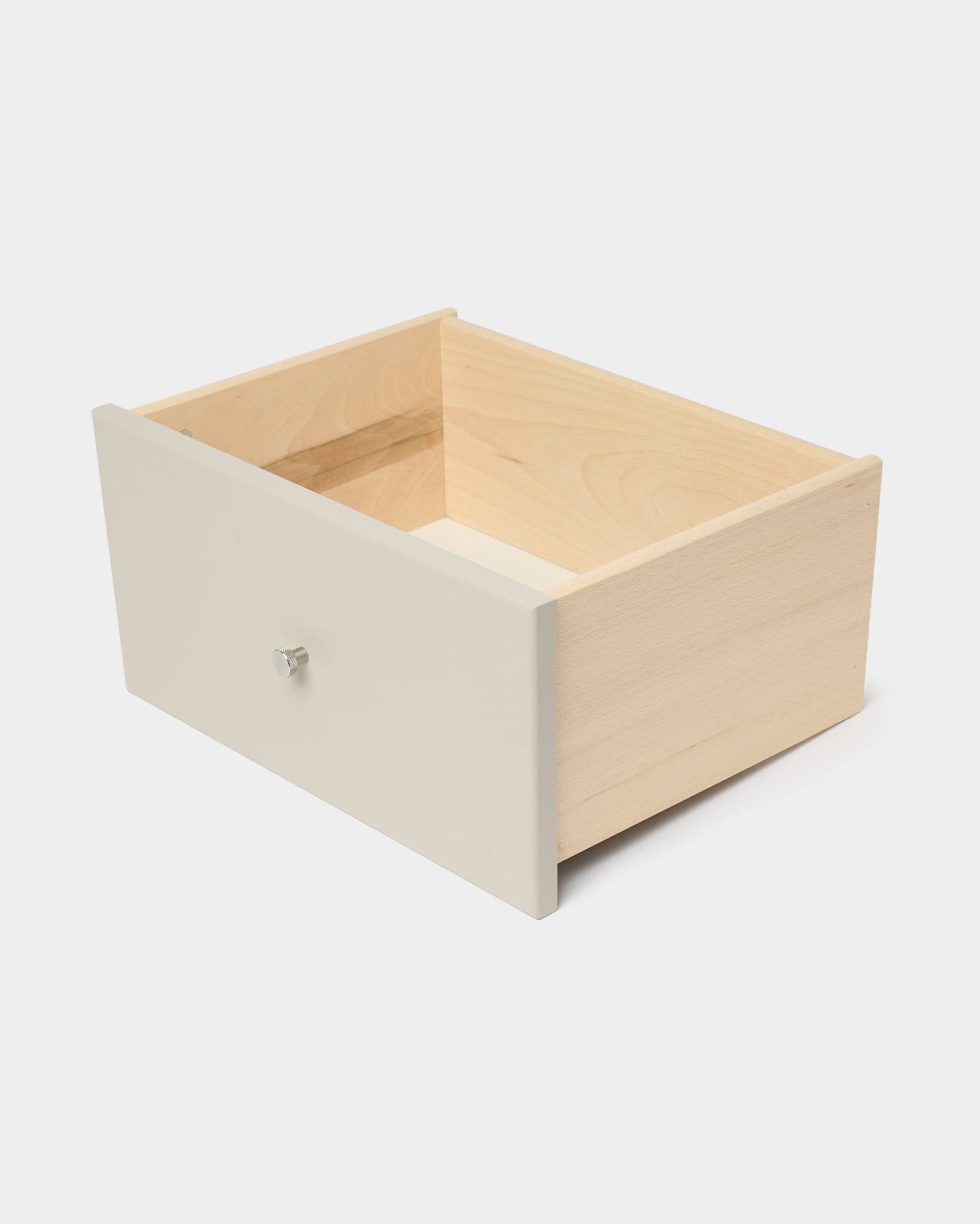 WoodUpp Arka bokhylla med låda i beige med vit frontpanel och knopp, avsedd för sluten förvaring, avbildad mot en enfärgad vit bakgrund.