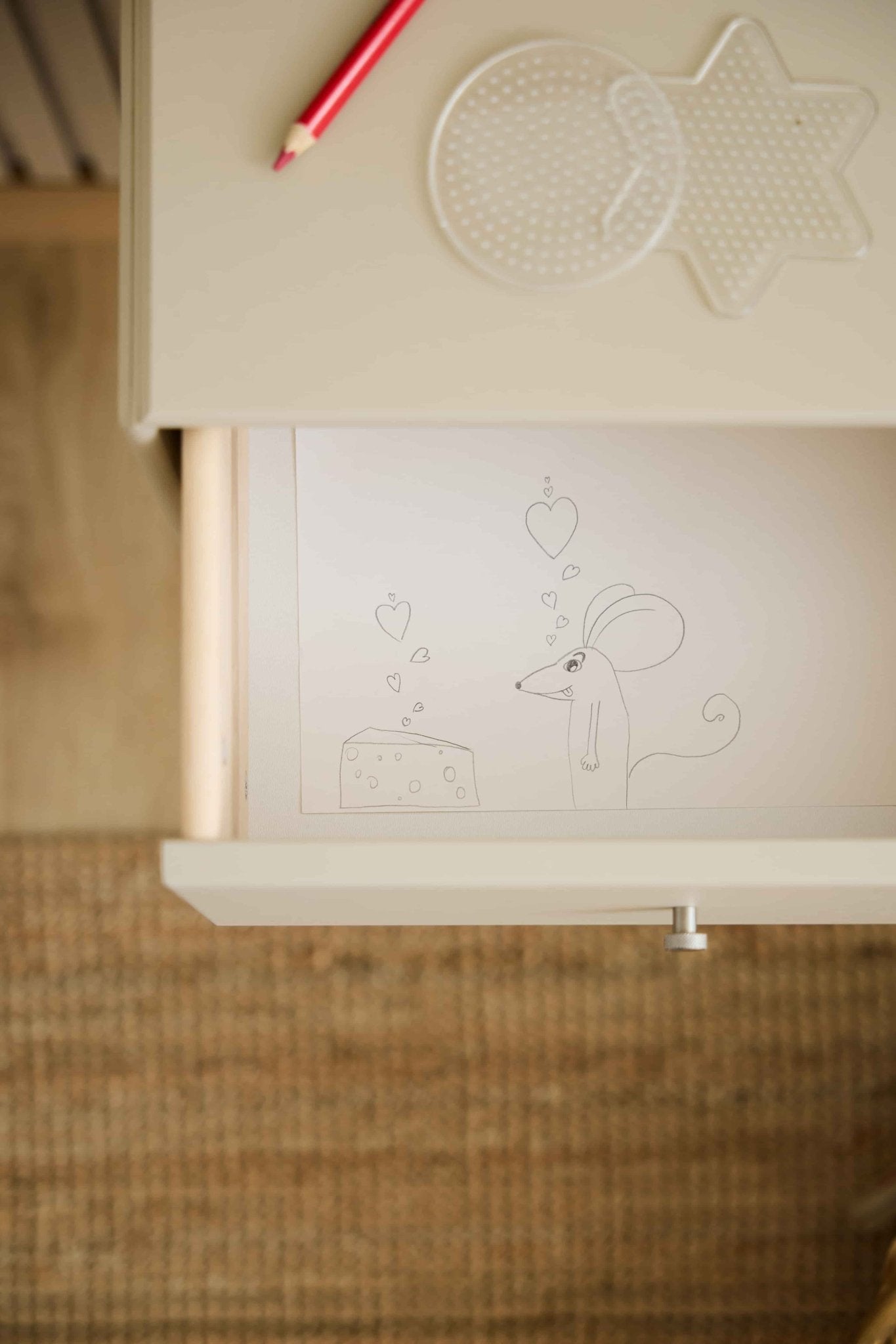 WoodUpp Arka bokhyllalåda i beige med motiv av mus och ost, röd penna och hålskivor; avsedd för förvaring i stängda fack i bokhyllsystemet.