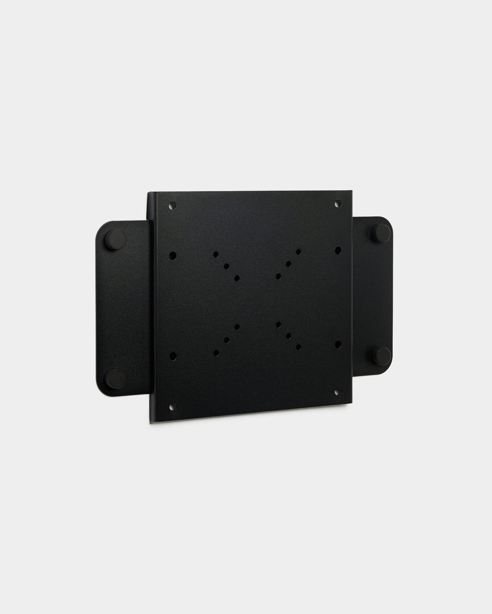 Fjell | TV Mount (small) från WoodUpp, ett black metallbeslag med flera skruvhål och magnetiskt lås, visas mot en vit bakgrund.