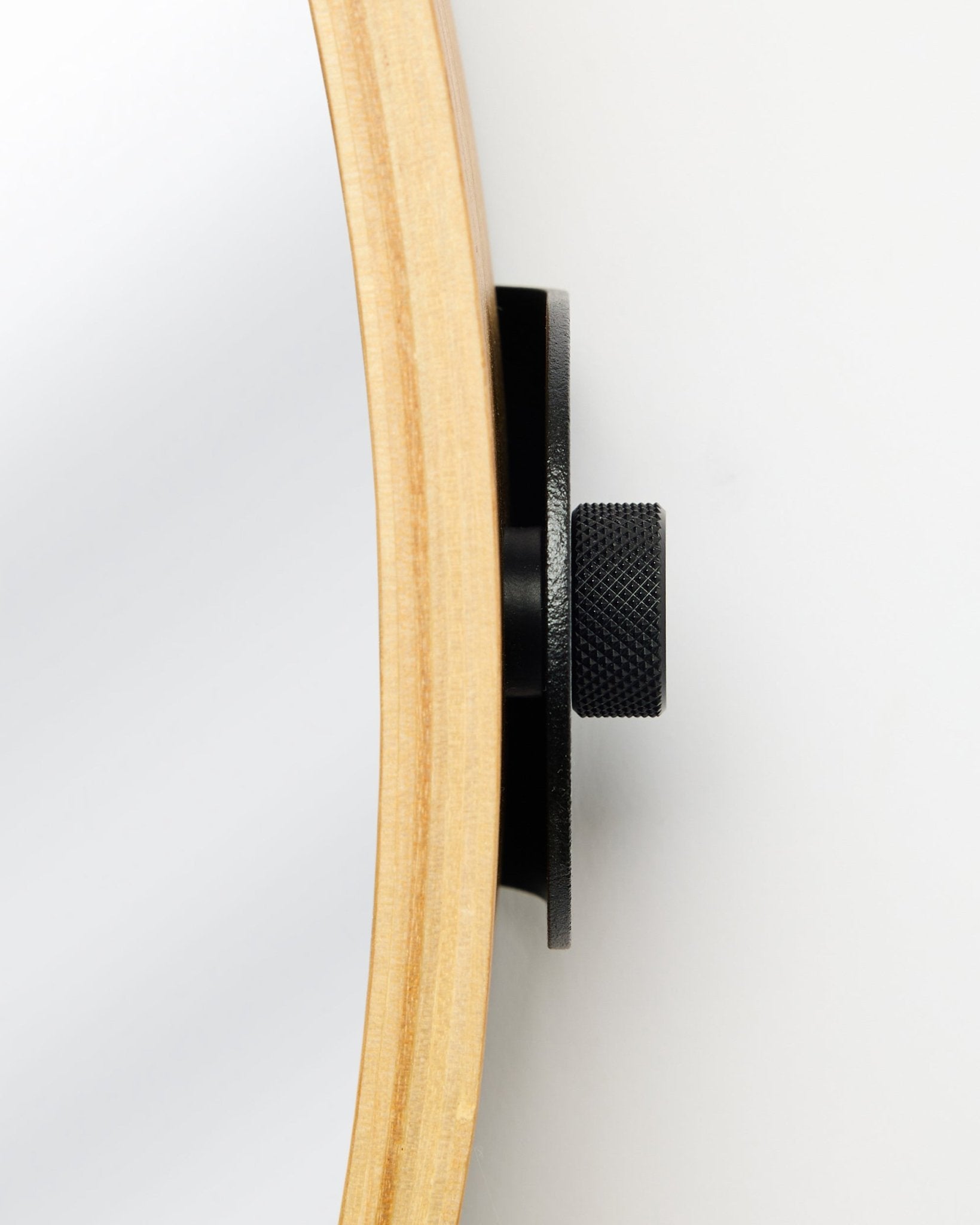 Närbild från sidan av WoodUpp Linn | Mirror i Natural Oak, med en rund ram i ek och knopp i metall i black, en accessoar för akustiska träpaneler.