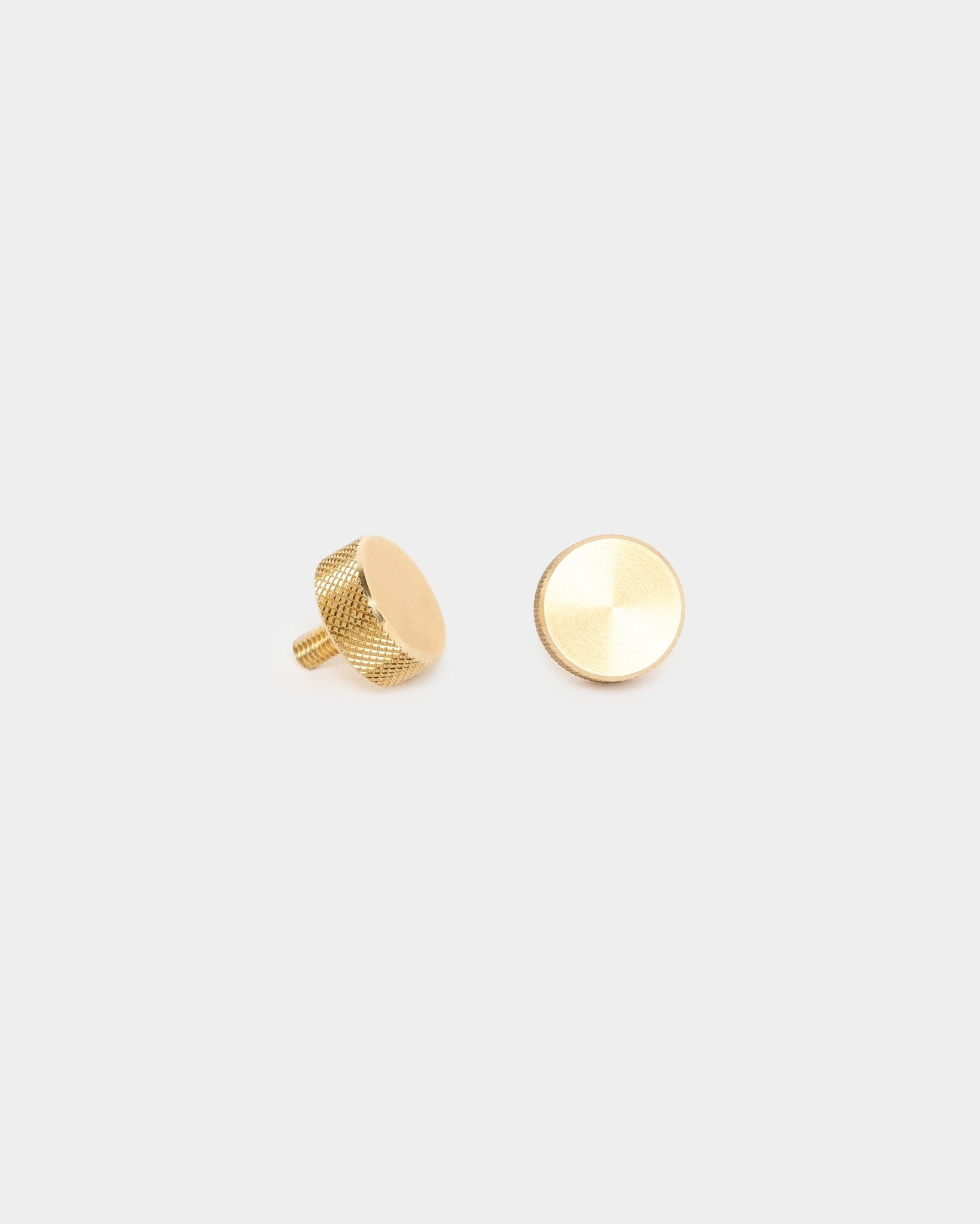 Ett par WoodUpp brass fingerskruvar (M5x10mm, 20x8.8) med texturerade sidor och skruvstift, utformade som tillbehör för montering av akustikpaneler eller rumsavdelare.
