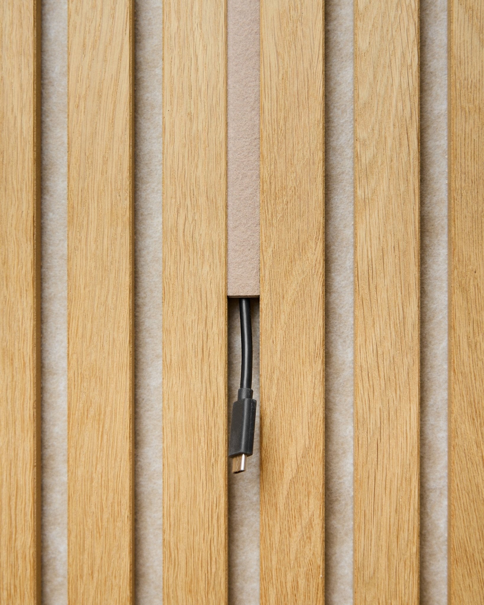 Dupps Pop-on Cable Cover (beige, set om 3) från WoodUpp döljer kablar mellan Akustikpanel lameller, och lämnar bara kontakten synlig för en ren och enhetlig finish.