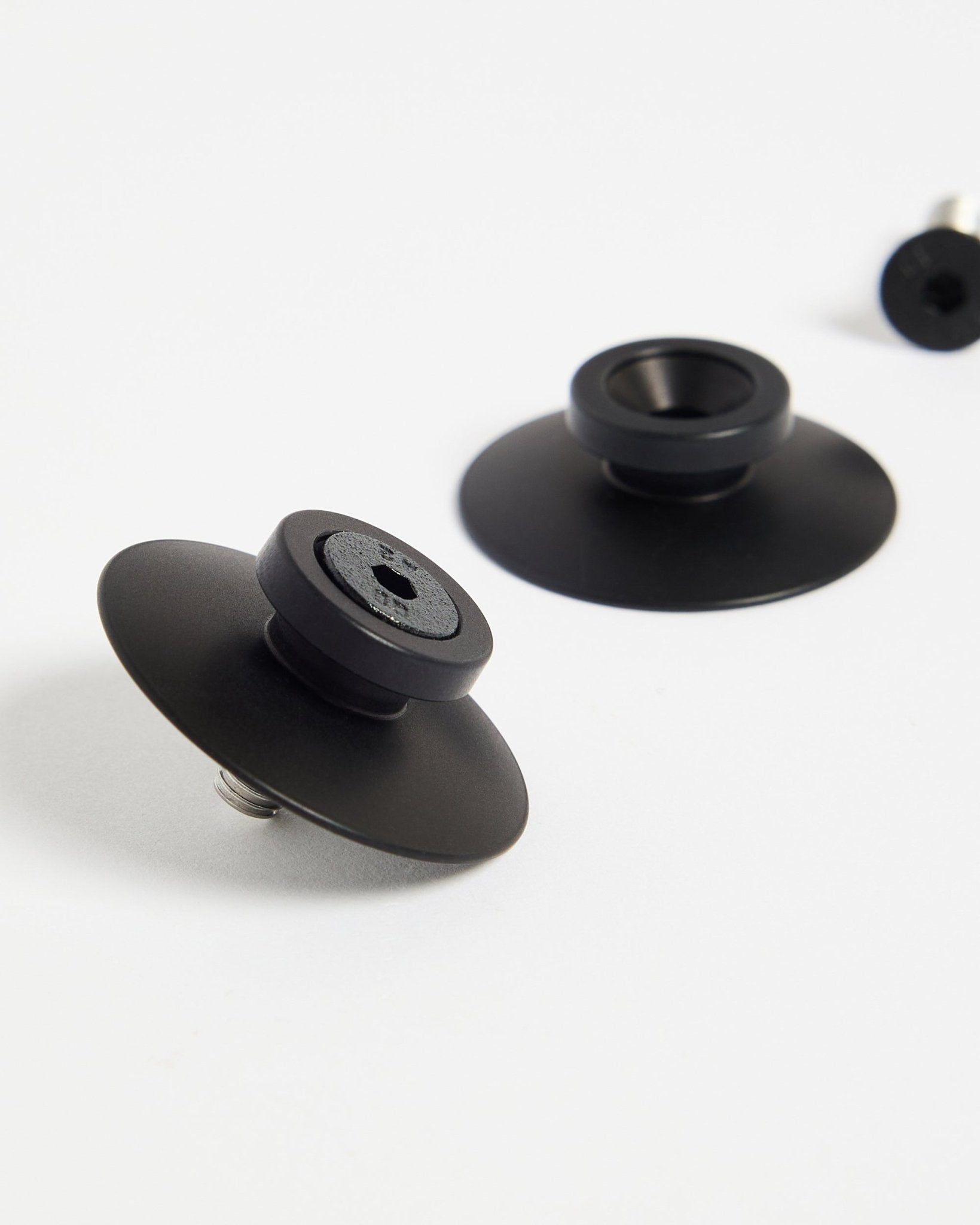 Två black aluminiumfästen Dupps från WoodUpp (2 st) på en vit yta, utformade för att montera akustikpaneler eller rumsavdelare säkert.