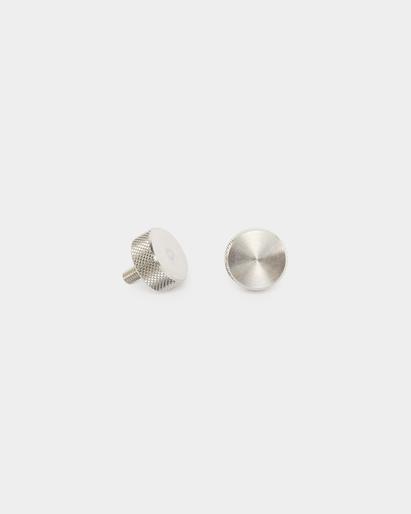 Två WoodUpp fingerskruvar i rostfritt steel (M5x10 mm, 20x8.8), tillbehör för Akupanel akustikpaneler, visade stående och liggande mot en enkel vit bakgrund.
