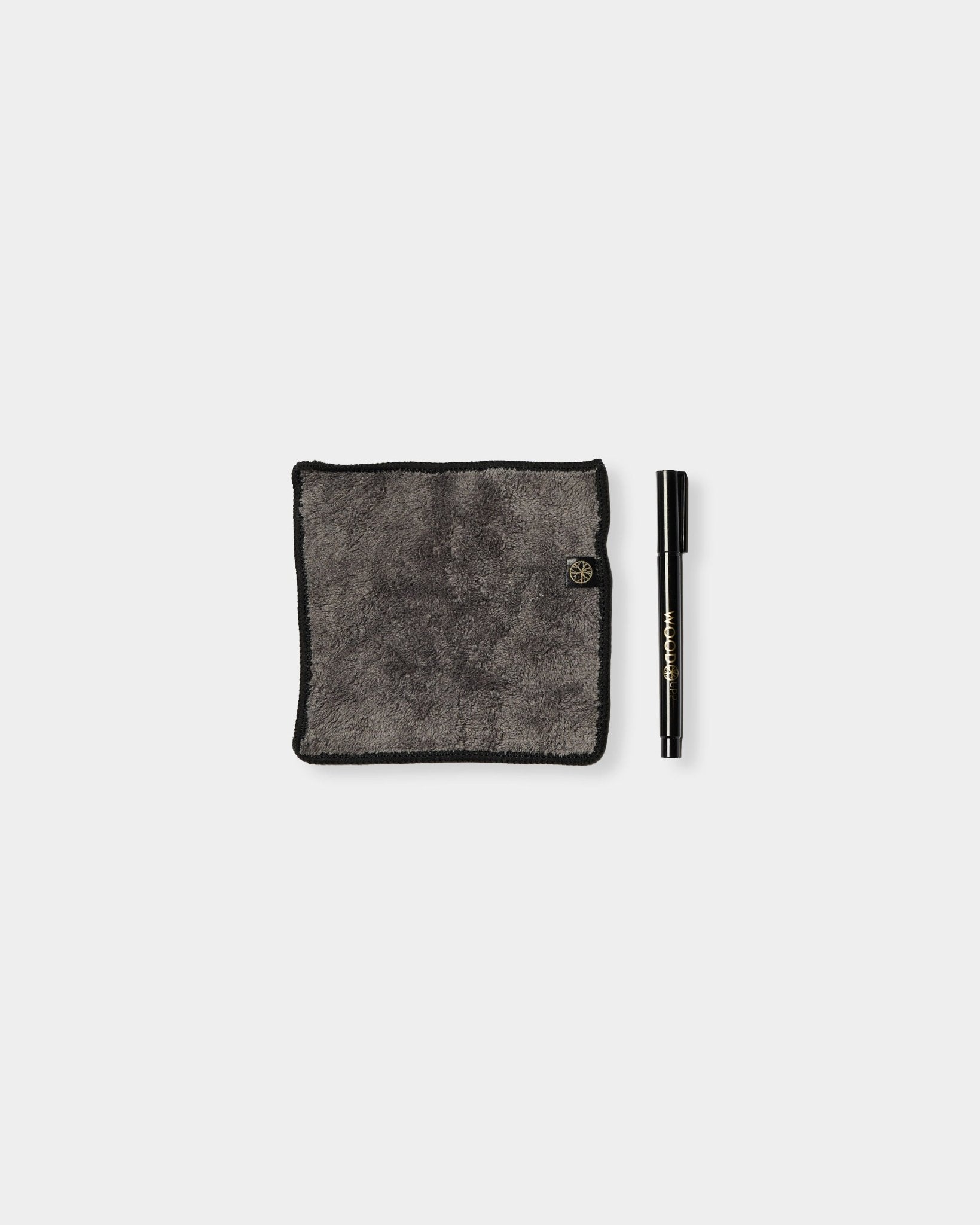 Blackboard-setet Norr från WoodUpp innehåller en grå mikrofiberduk med black kanter och en kritbläckspenna, utformad för användning på magnetiska akustikpaneler.