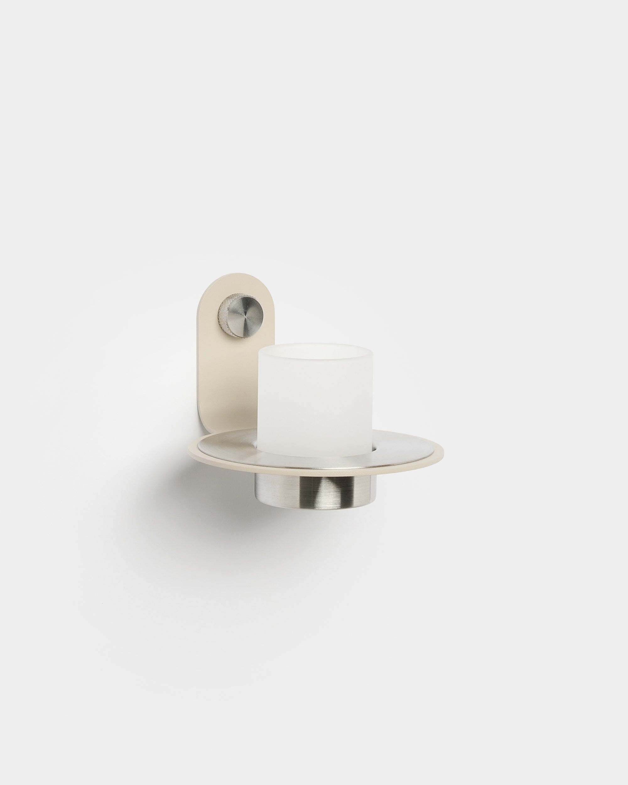 Norr Candle Holder från WoodUpp, med en bas i beige rostfritt steel, placerad på en Akupanel Akustikpanel för en modern nordisk accent.