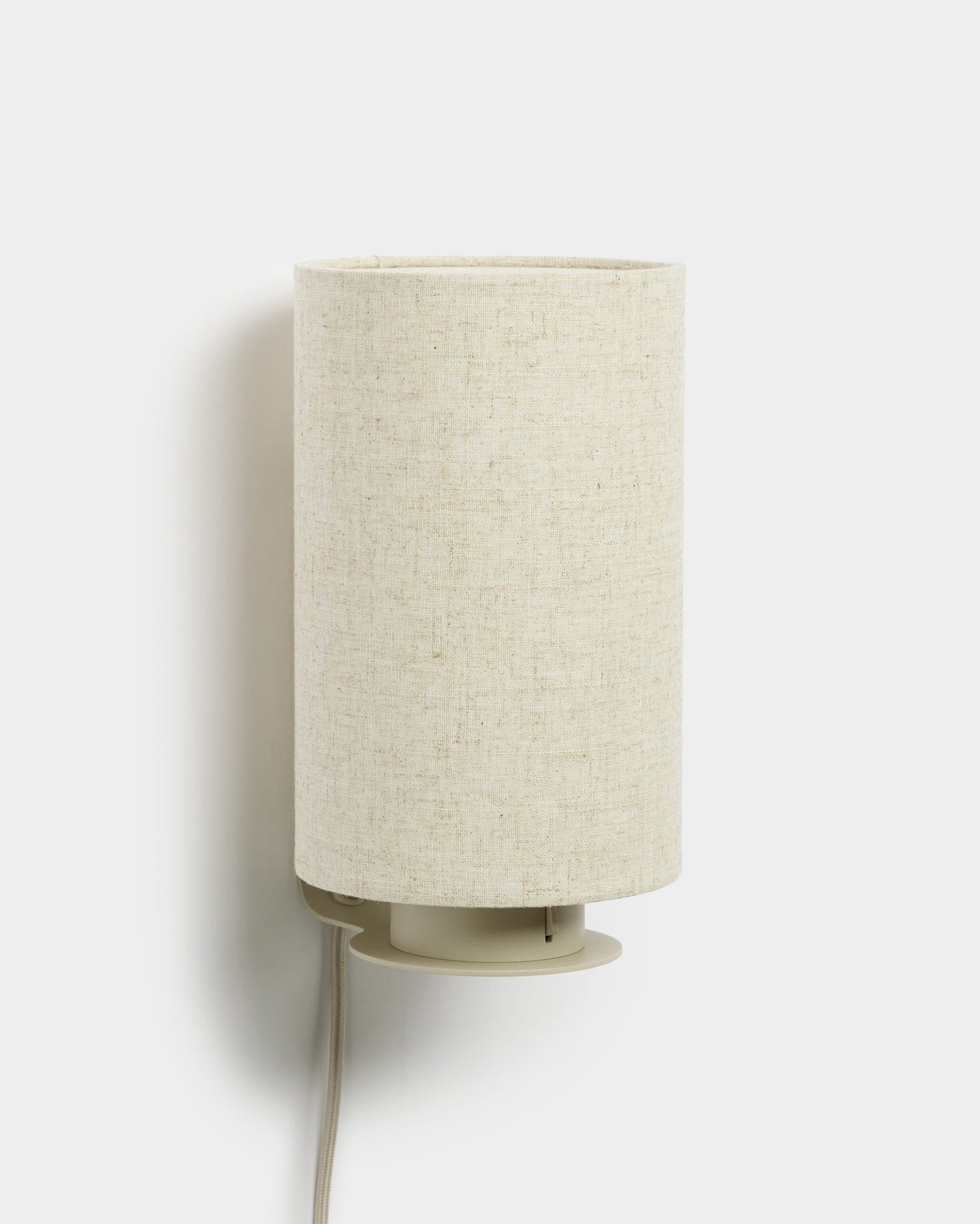 Feya | Wall Lamp från WoodUpp med en cylindrisk skärm i linne-bomull och synlig vit sladd, beige finish, formgiven för att komplettera akustiska träpaneler.