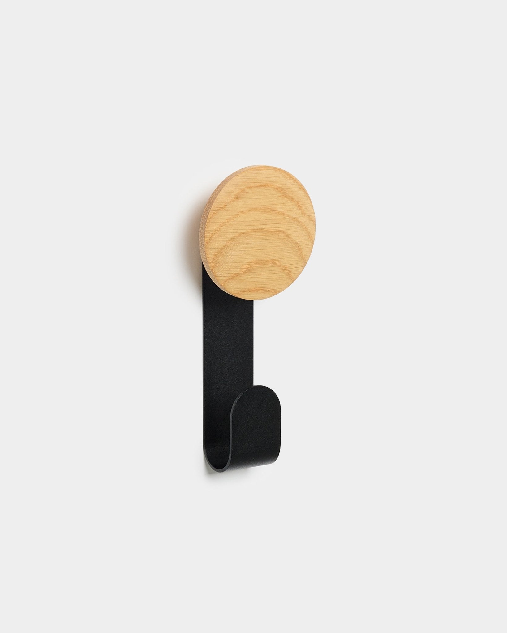 Linn Vertical Hanger från WoodUpp med rund topp i natural oak och krok i black, utformad för att hänga upp tillbehör på Akupanels Nordic akustikpaneler i trä.