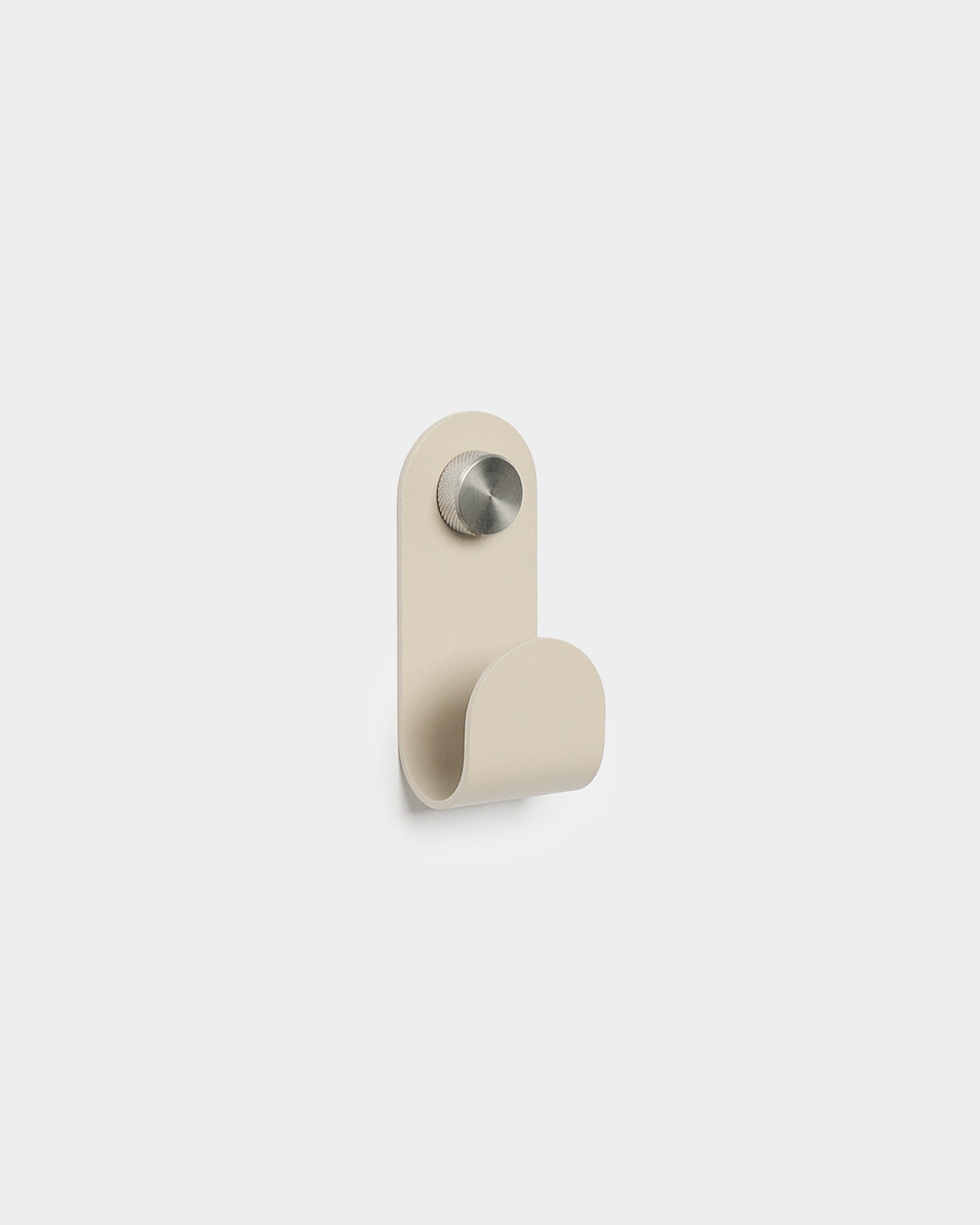 WoodUpp Norr Single Hanger i beige med en minimalistisk böjd form och borstad metallfinish, utformad som ett tillbehör för kompakta väggkrokar till Akupanel.