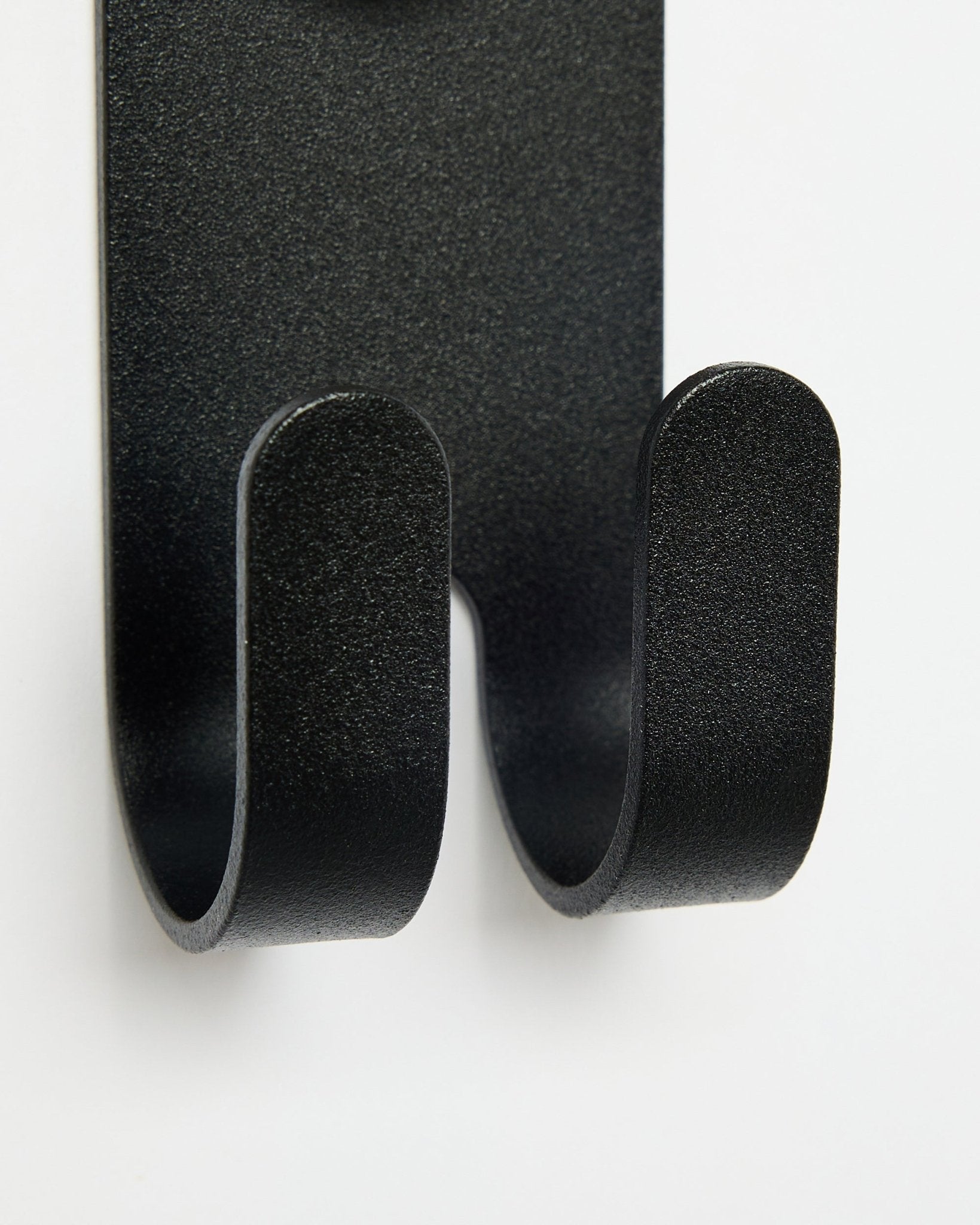Närbild av Norr Double Hanger i black från WoodUpp, som visar dubbla krokar utformade för Akupanel tillbehör mot en vit bakgrund.