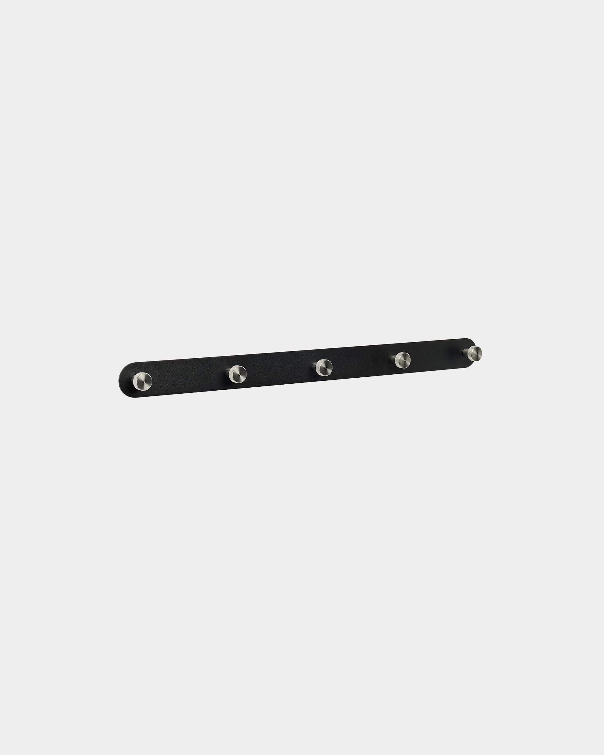 WoodUpp Norr klädhängare X5 i black och rostfritt steel, med fem jämnt placerade krokar, monterad mot en enkel vit bakgrund. Nordisk minimalistisk design.