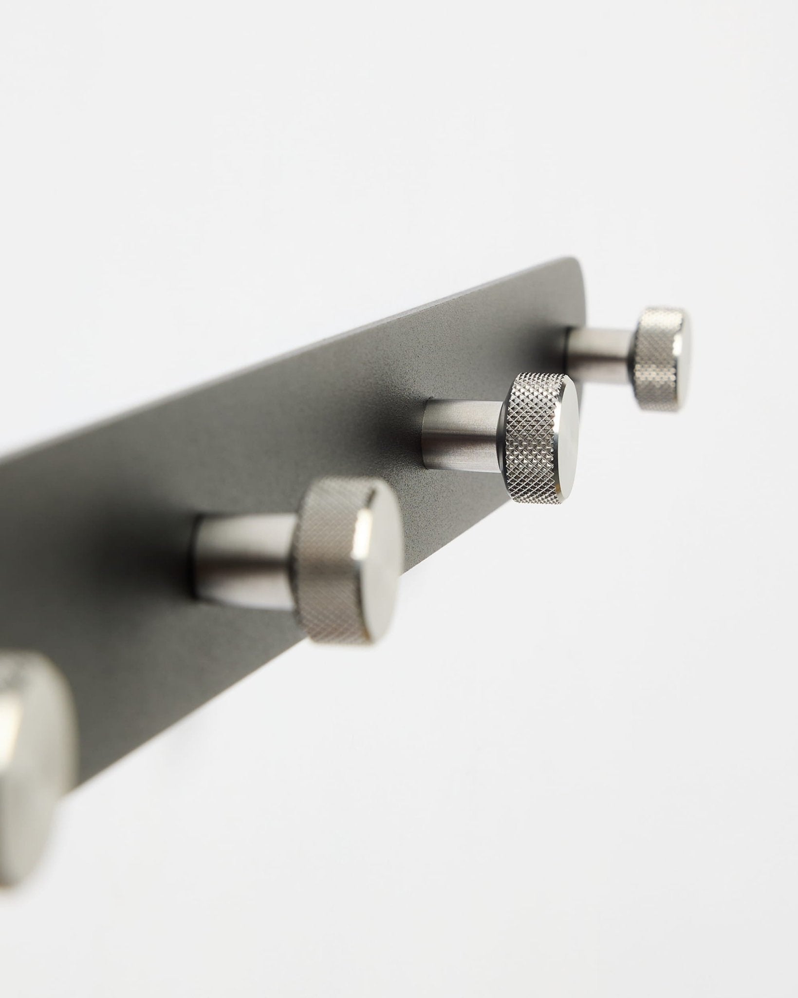 WoodUpp Norr Coat Hook Rack X7 i svart och rostfritt stål med sju krokar, visad mot en slät vit bakgrund; del av accessoarkollektionen CREATE.