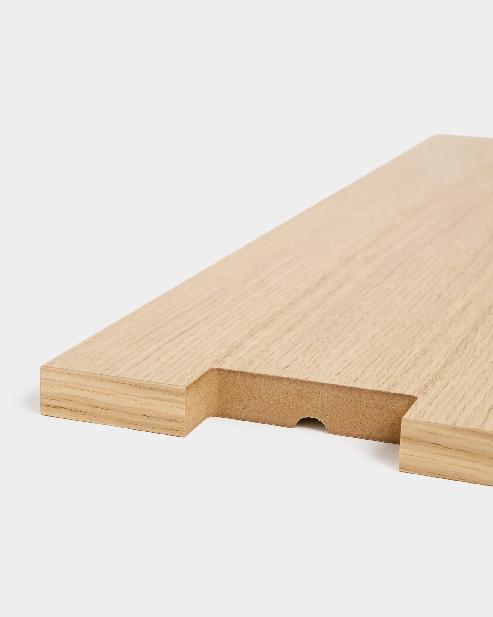 Lova | Wood Shelf BM2 i ekfaner från WoodUpp, 65,8 x 20 cm, visad i närbild med ett urtag och ett halvcirkelformat spår mot vit bakgrund.