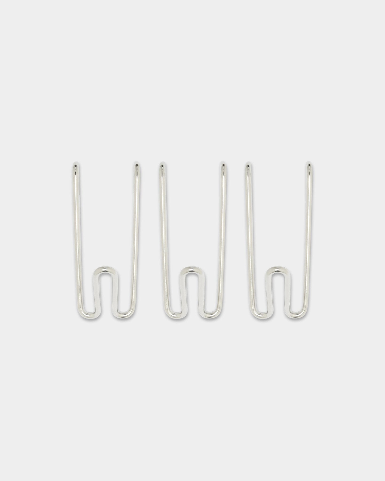 Tre Alva Wire Hooks BM1, korta, i rostfritt steel från WoodUpps CREATE-kollektion, jämnt placerade mot en enfärgad vit bakgrund.
