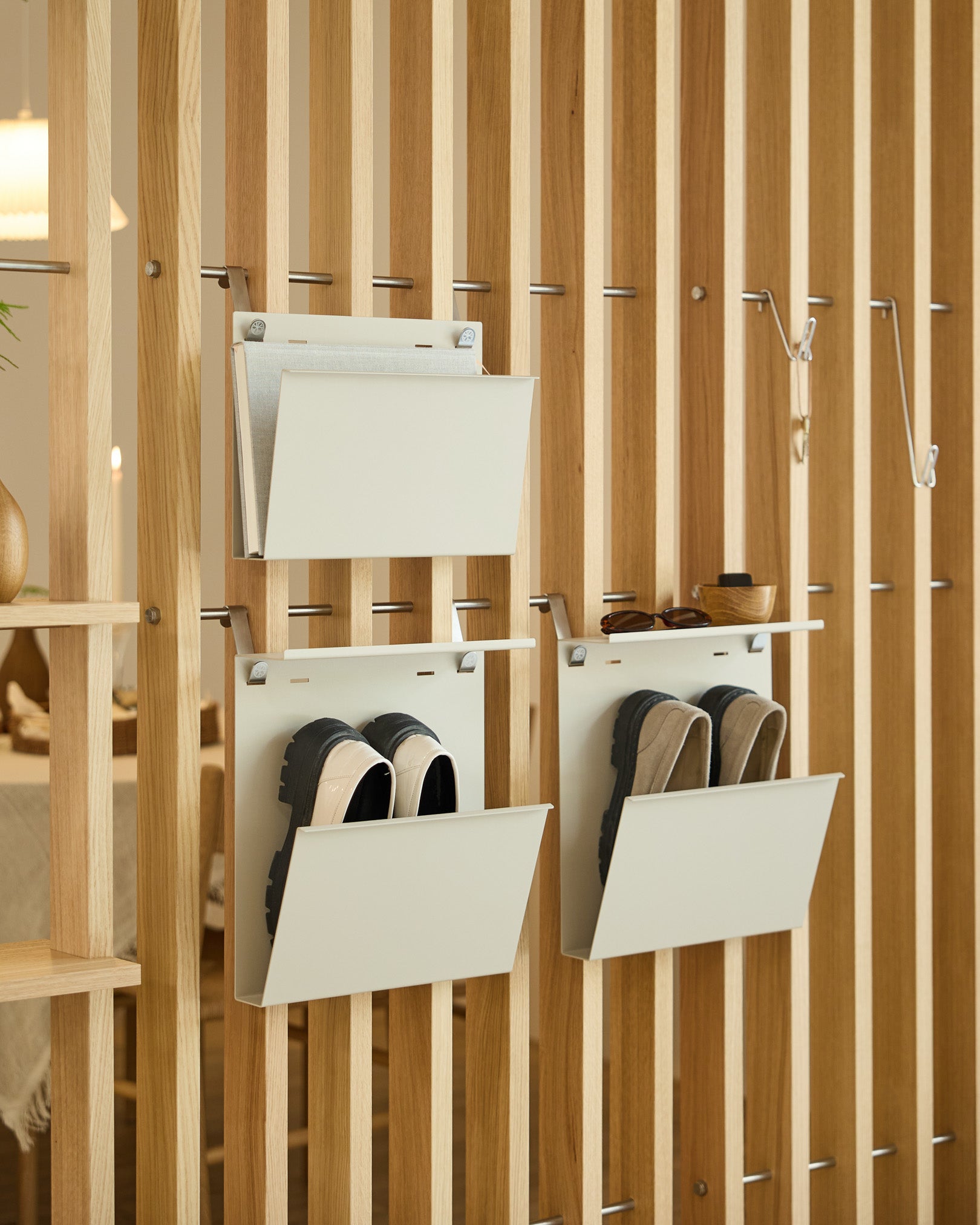 Nell Magazine Storage från WoodUpp i beige är fäst på en vertical rumsavdelare och ger ordnad förvaring för magasin och small föremål.