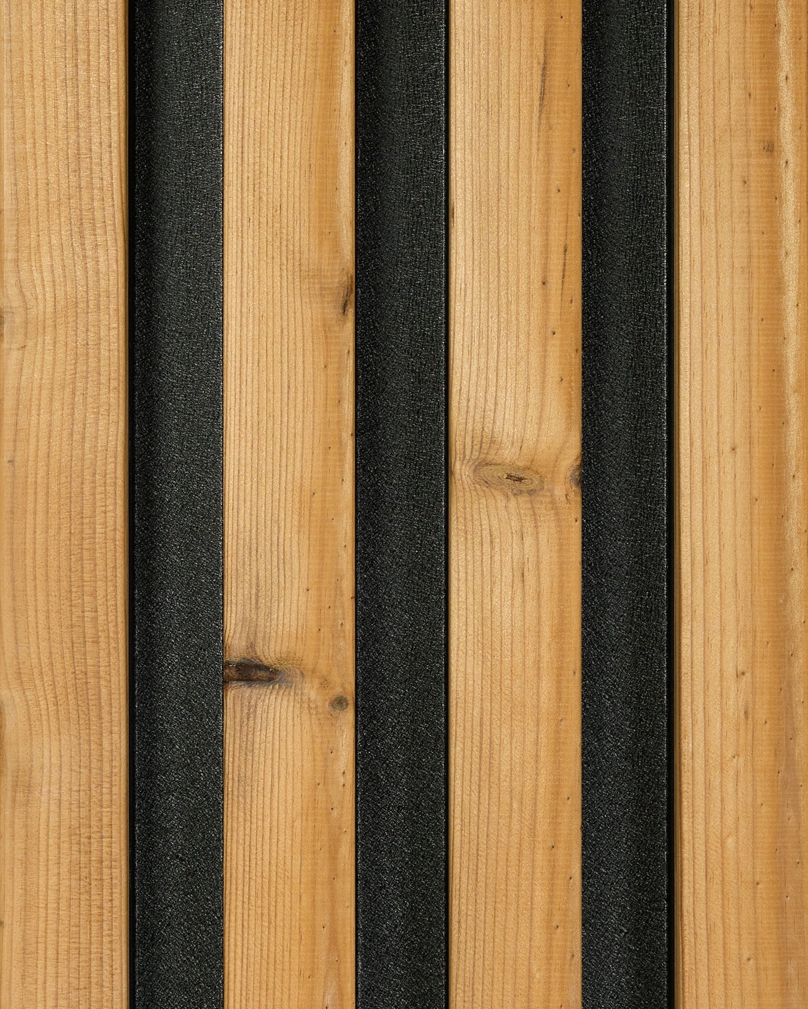 Provbit av Aluwood fasadpanel i brown (45,7 x 27 cm) från WoodUpp, med träådrade plankor i vertical och lister i black som skapar ett modernt randigt uttryck.