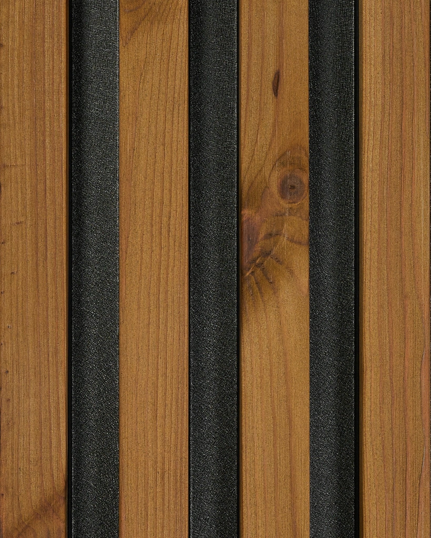 Närbild av prov på WoodUpp Aluwood fasadpanel i oljad brown finish (45,7 x 27 cm), som lyfter fram natural wood ådring och black texturerade ribbor.