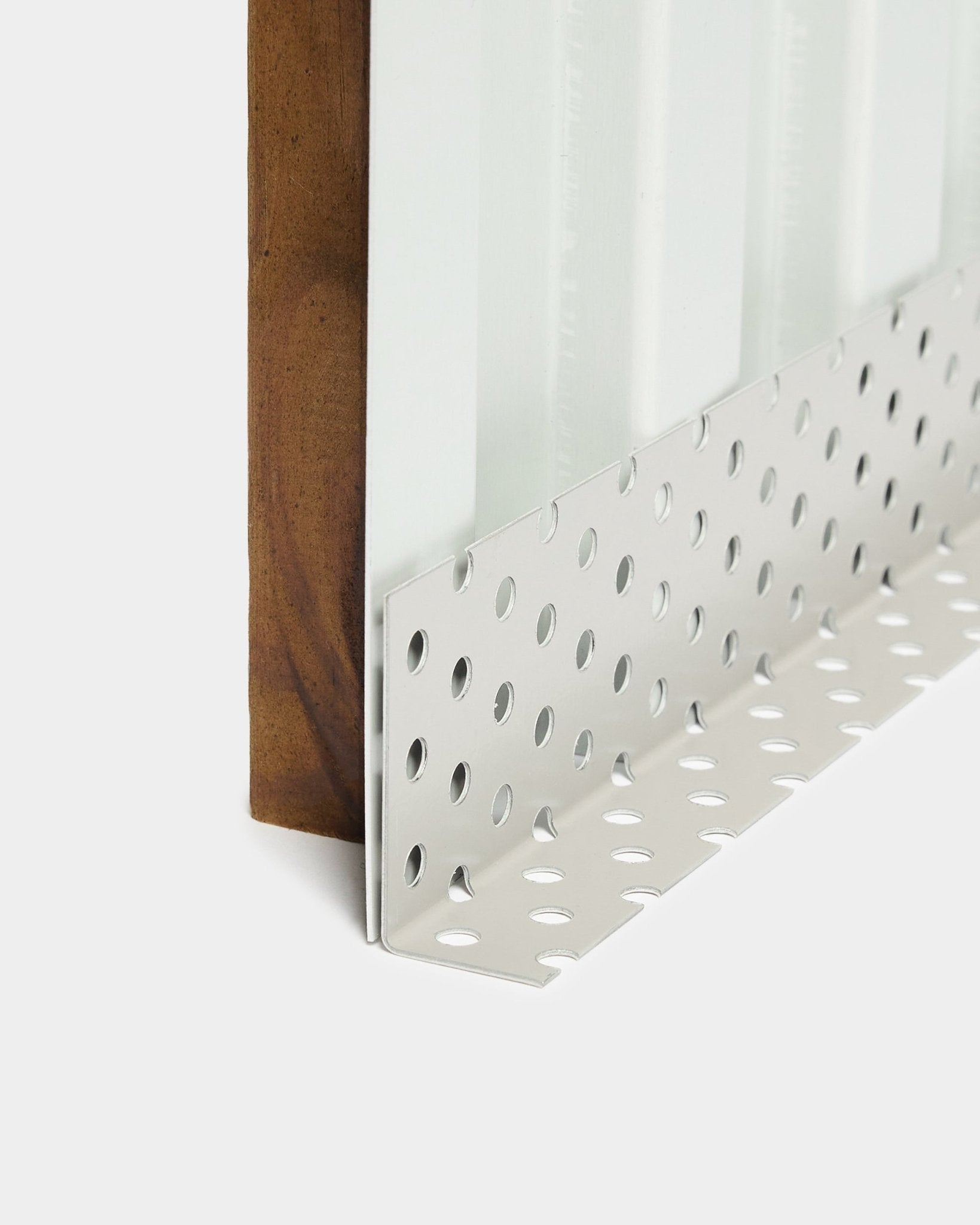 Närbild av installationstillbehör för Aluwood fasadpaneler: hörnprofil i metall med large runda perforeringar, utformad för ventilerade luftspalter, 240 cm längd.