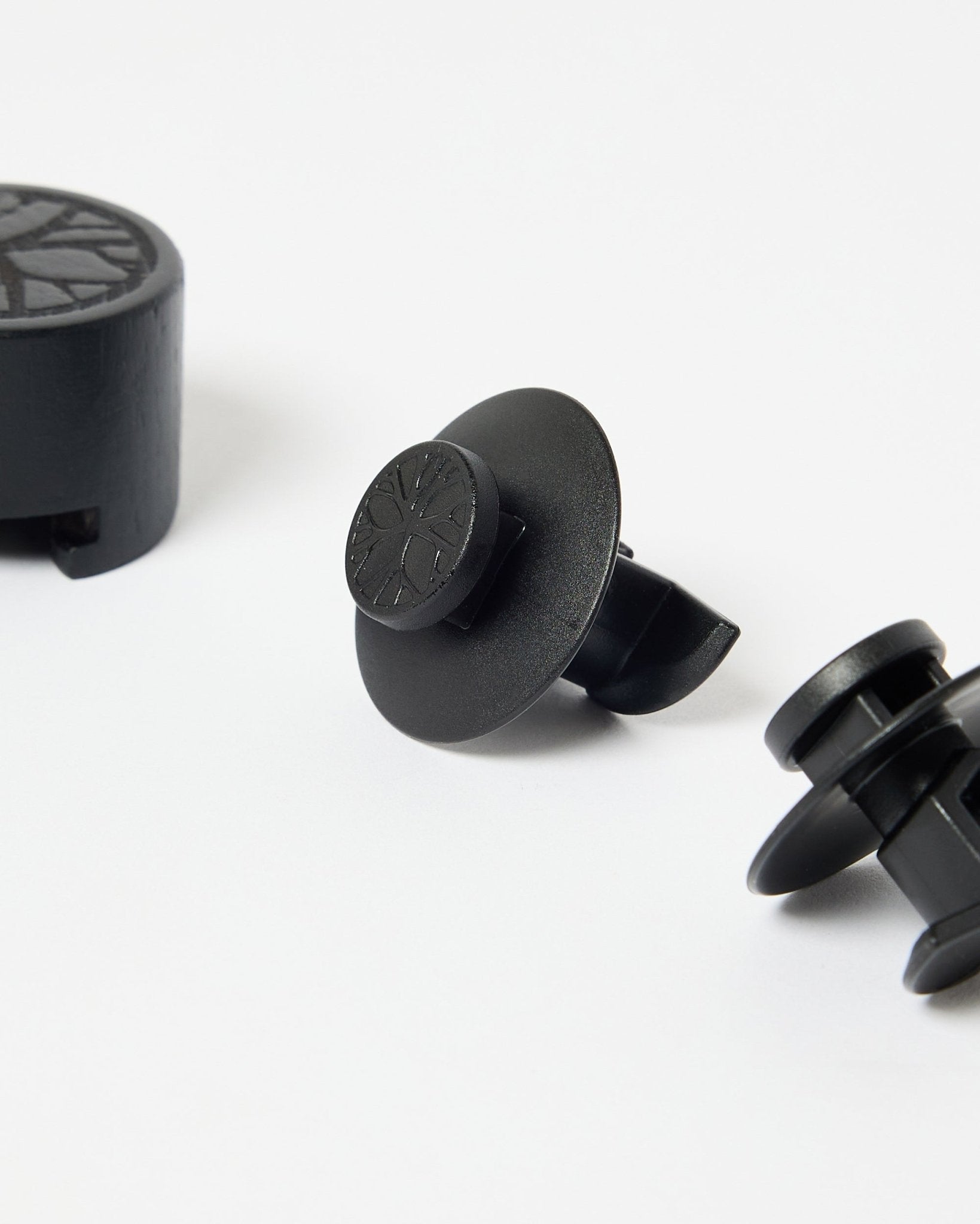 Set med 3 black nylonfästen med cirkelformade toppar och installationsverktyg, utformat för montering av WoodUpp akustikpaneler eller ribbväggspaneler.