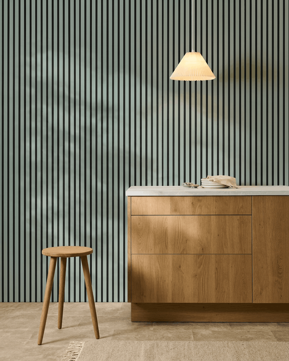 Minimalistiskt nordiskt kök med en träpall, ett skåp och WoodUpp Akupanel Akustikpanel i färgen Cloud med black filt (240x60cm) för akustisk komfort.