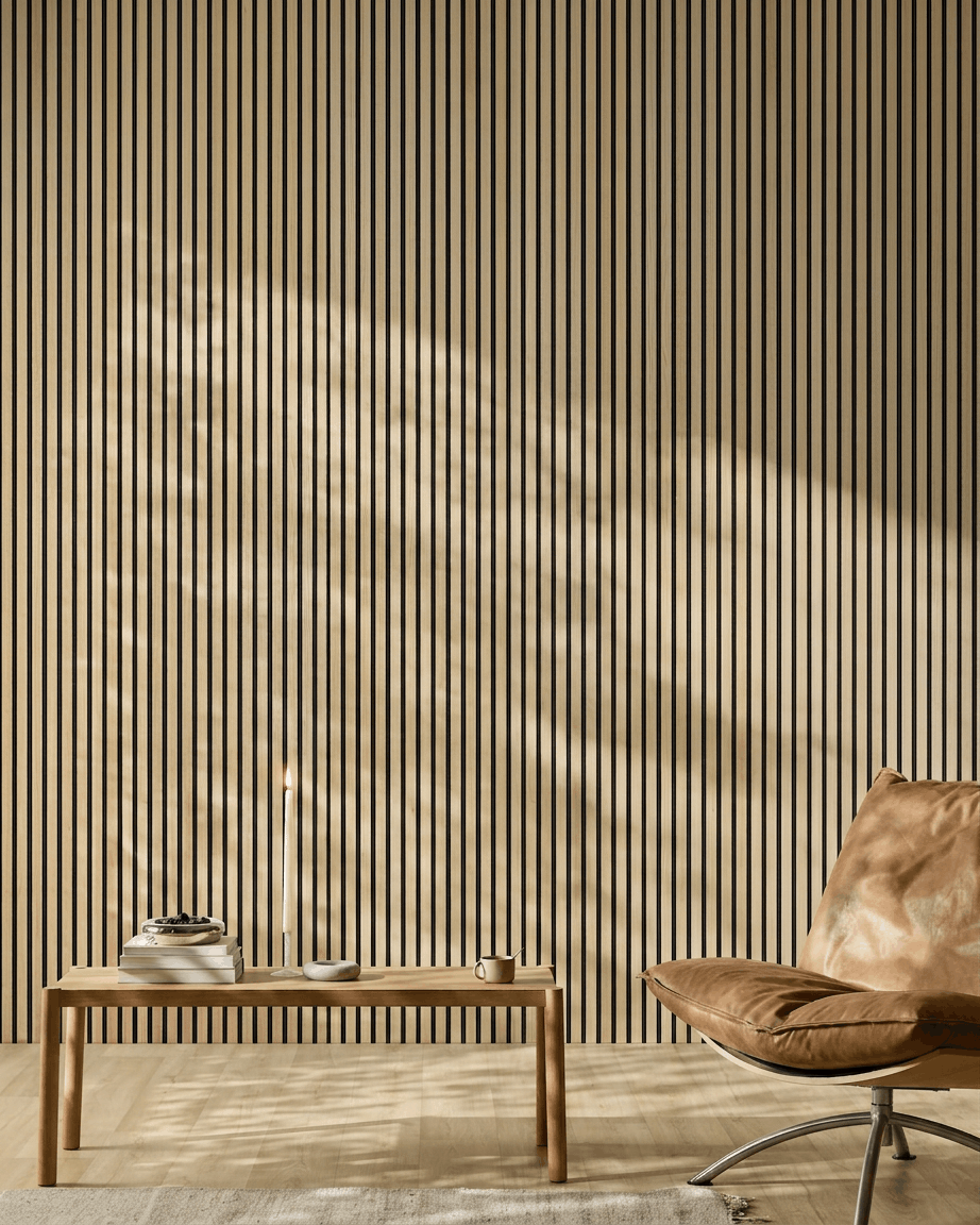 Minimalistiskt rum med en WoodUpp Akupanel akustikpanel i trä i Classic Oak, läderfåtölj, träbord, ljus och solljus som kastar skuggor.