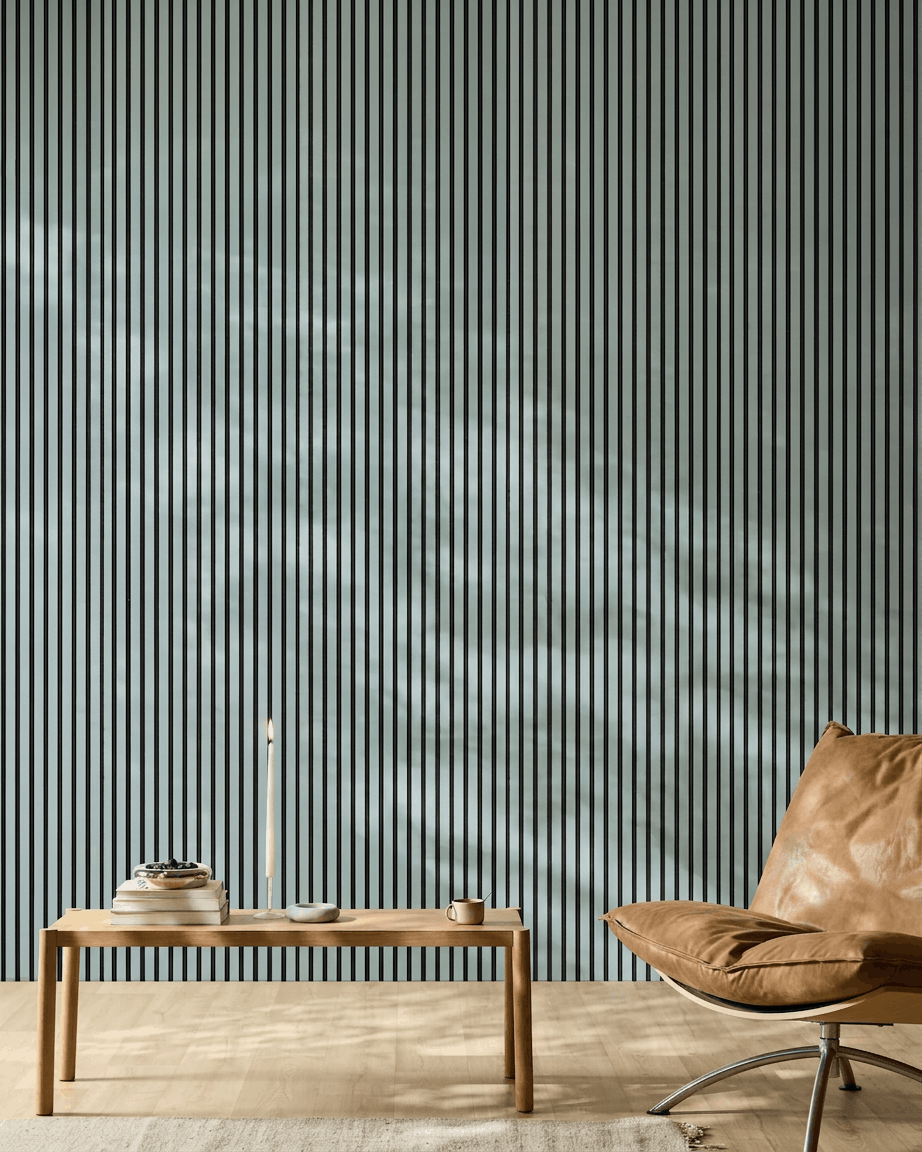Minimalistiskt rum med en träbänk, böcker och en brown läderfåtölj framför en WoodUpp Akupanel Akustikpanel i färgen Cloud med black filt.