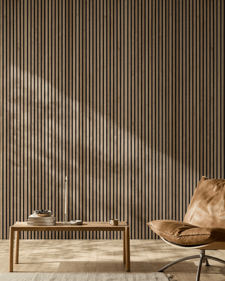 Minimalistiskt nordiskt rum med akustisk träpanel från WoodUpp i valnöt Akupanel, en stol i ljusbrunt läder och ett soffbord i trä med böcker och ett ljus.