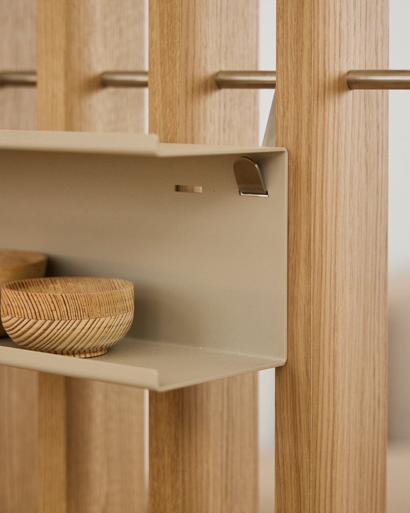 Närbild av WoodUpp Nell Double Metal Shelf / BM1 i beige, 63,5 cm, med flätade skålar och vertical nordiska akustikribbor i trä monterade på steel stänger.